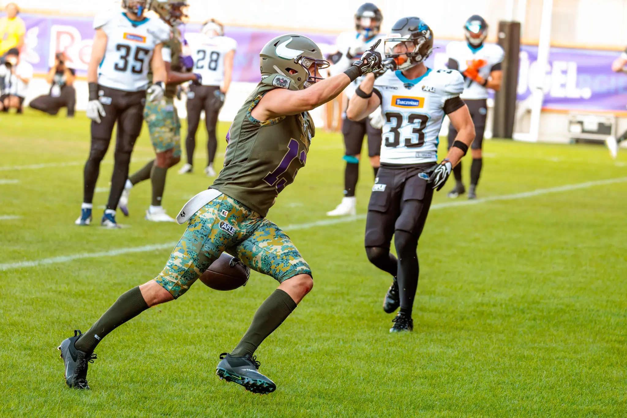 Vikings-Spieler Philipp Haun (Nummer 13) läuft mit dem Ball, Panthers-Spieler Nummer 33 verfolgt ihn.