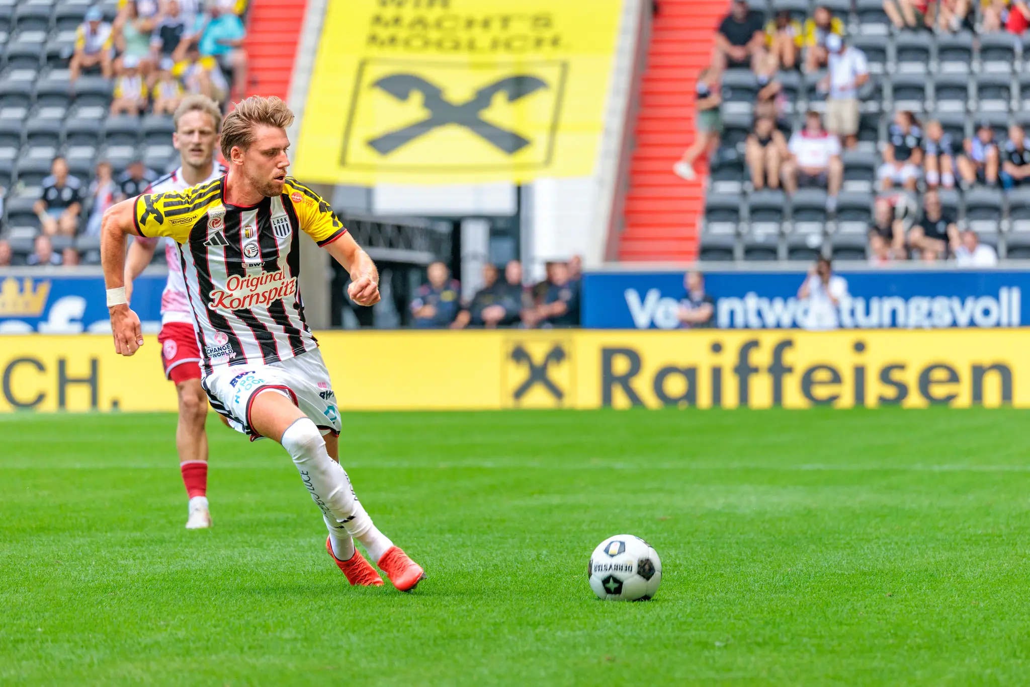 LASK-Spieler nimmt den Ball seitlich an und bereitet die Spieleröffnung vor, bereit zum Pass in die Tiefe.