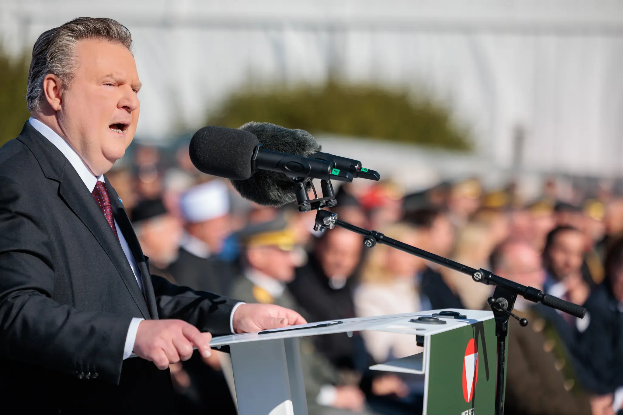 Michael Ludwig steht am Rednerpult und blickt über die Menge der Angelobung, hinter ihm sitzen Gäste in Uniform und Zivil.
