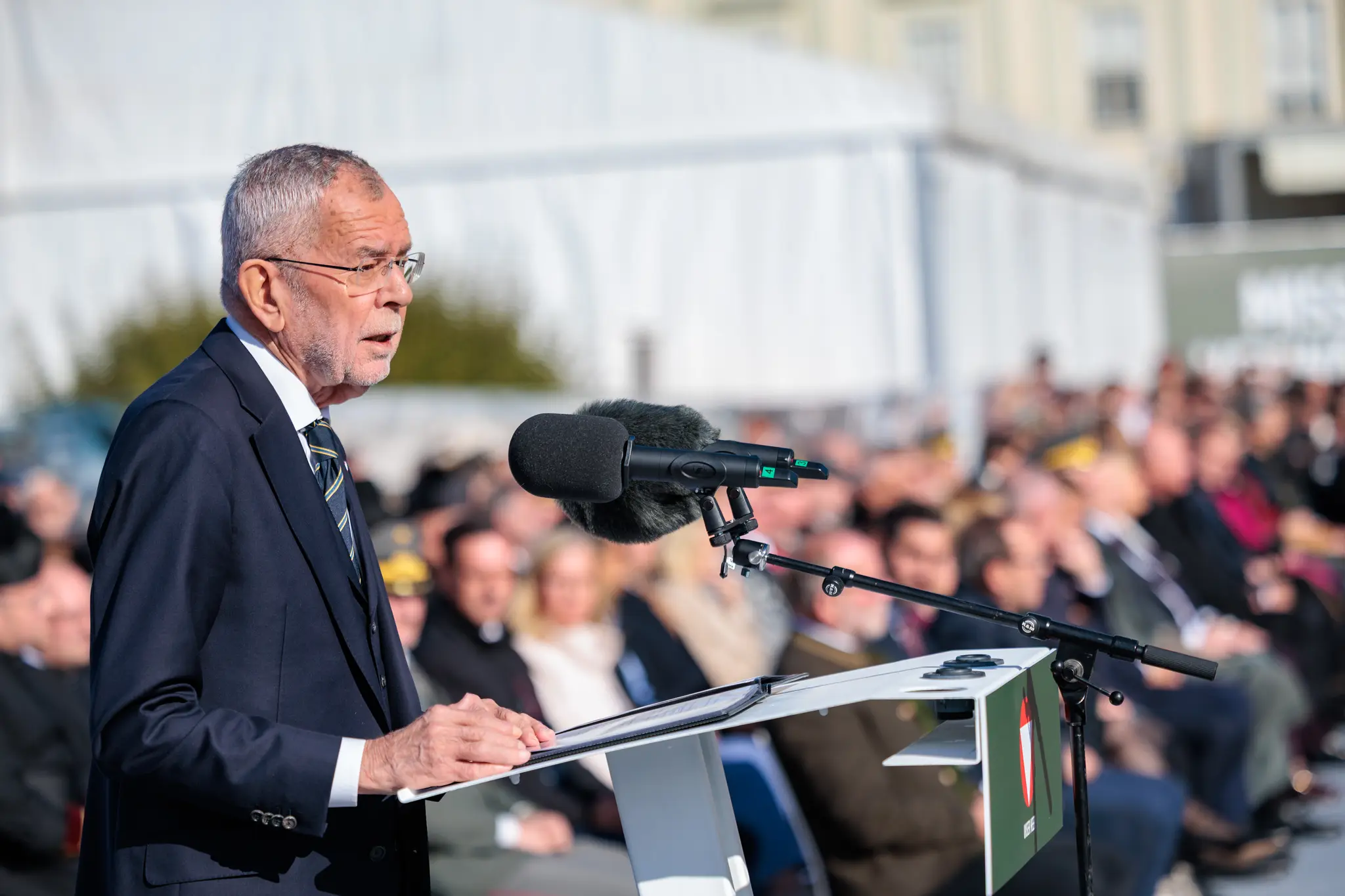 Alexander Van der Bellen liest seine Rede am Rednerpult, im Hintergrund sitzen Gäste und Militärs in der ersten Reihe.