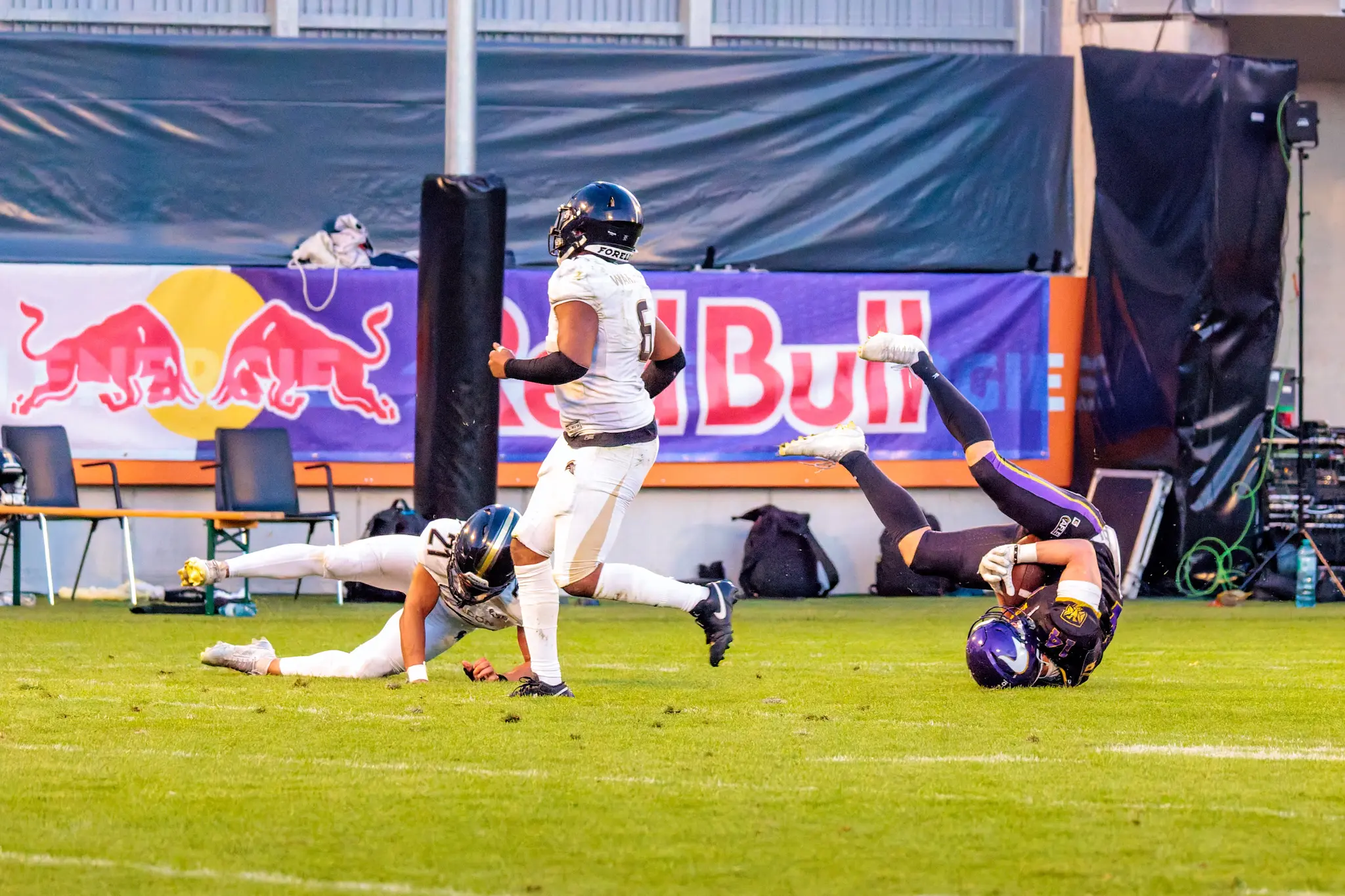 Weiter Pass der Vienna Vikings: Ein Receiver sichert den Ball am Boden und rollt ab, ein London-Verteidiger liegt daneben – Fang am Spielfeldrand.