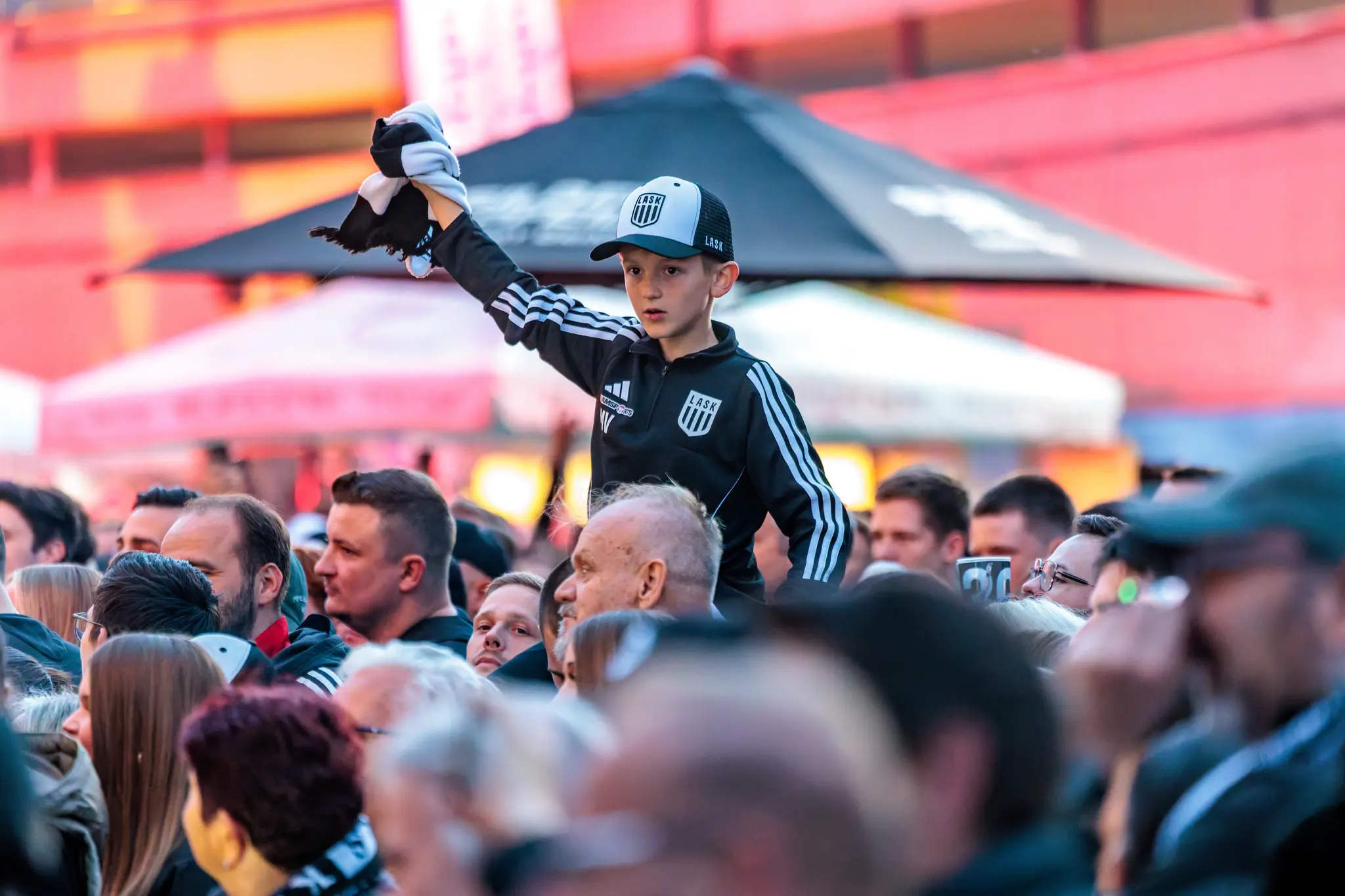 Ein junger Fan mit LASK-Cap jubelt während der emotionalen Meisterfeier auf dem Linzer Hauptplatz