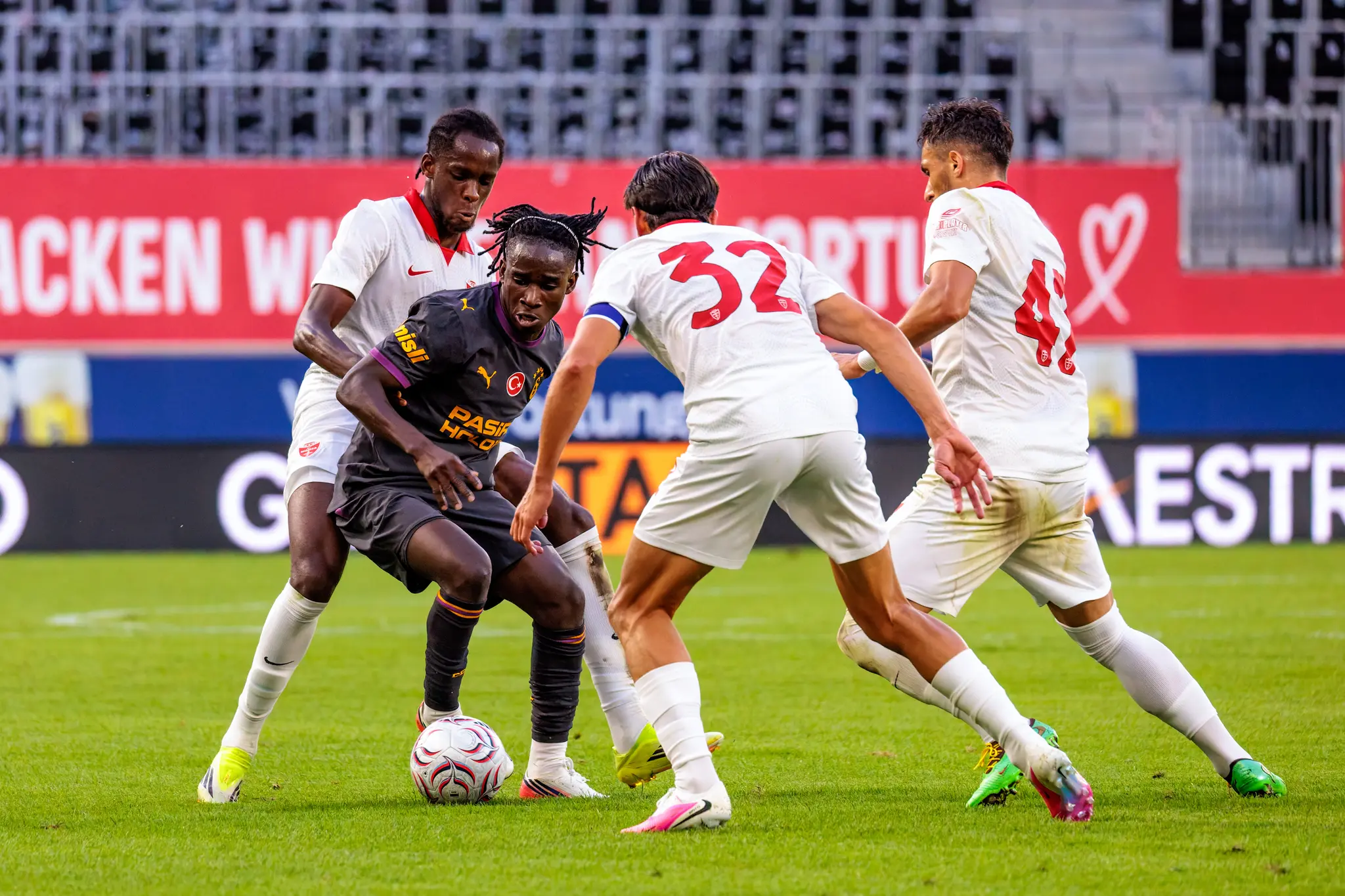Drei Monza-Spieler gegen einen Galatasaray-Spieler: Ballbehauptung im physischen Duell.