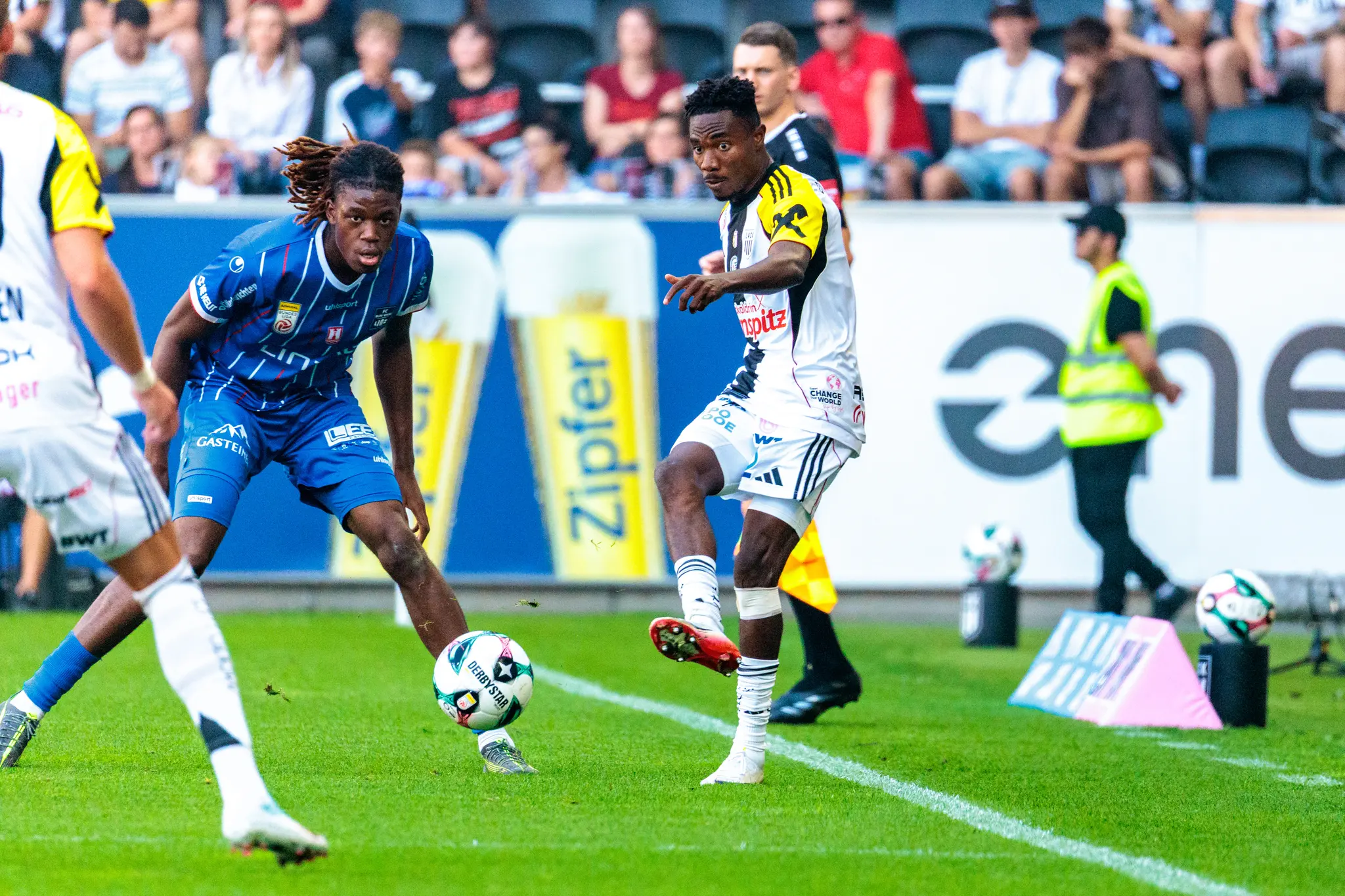 Elias Bakatukanda vom FC Blau-Weiß Linz bedrängt LASK-Spieler Moses Usor in einem intensiven Zweikampf um den Ball während des Linzer Derbys