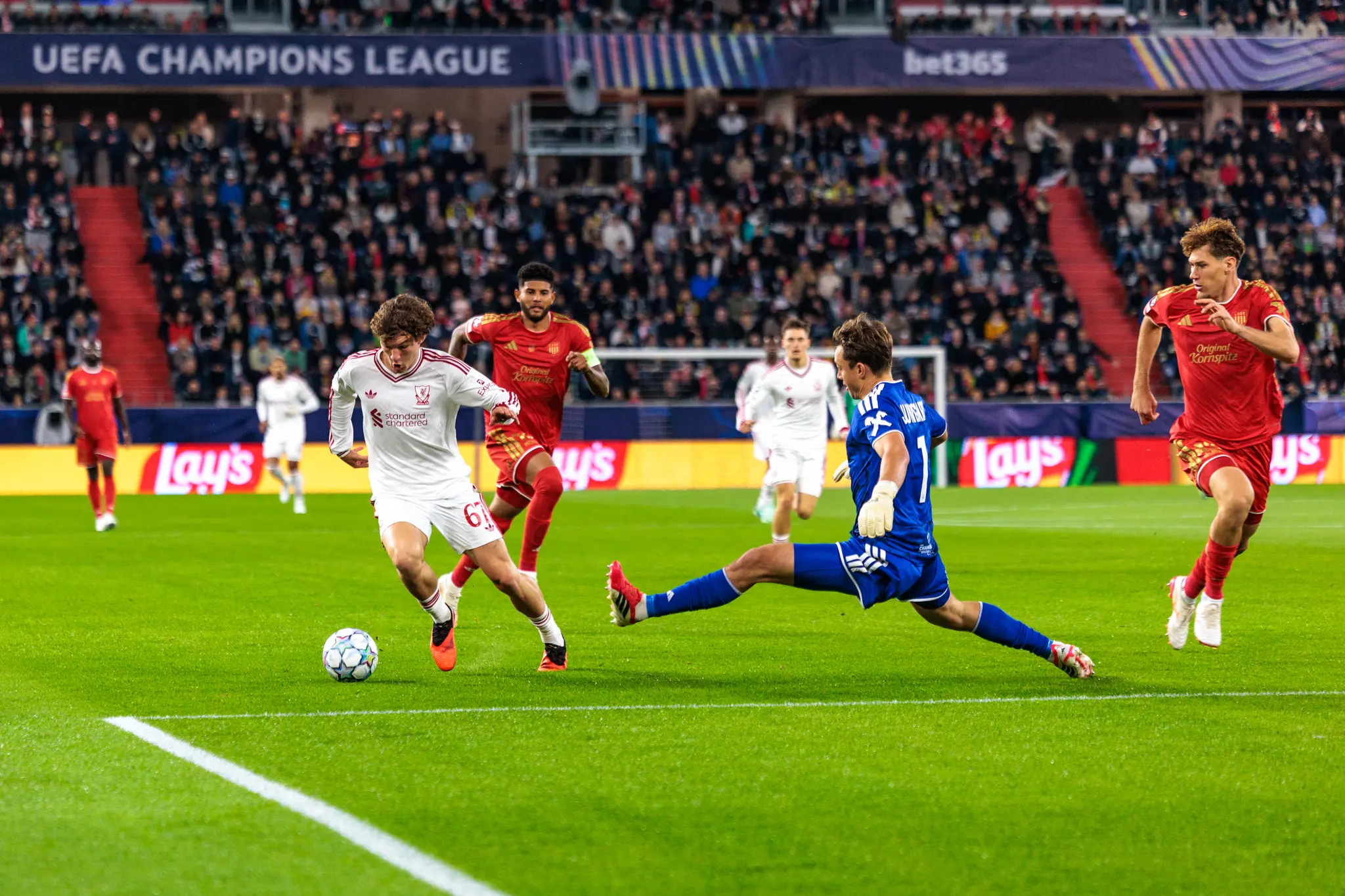 Lewis Koumas (67) weicht mit dem Ball am Fuß dem herausstürzenden LASK-Torwart Jungwirth (1) aus, dahinter läuft ein LASK-Spieler mit Kapitänsbinde.