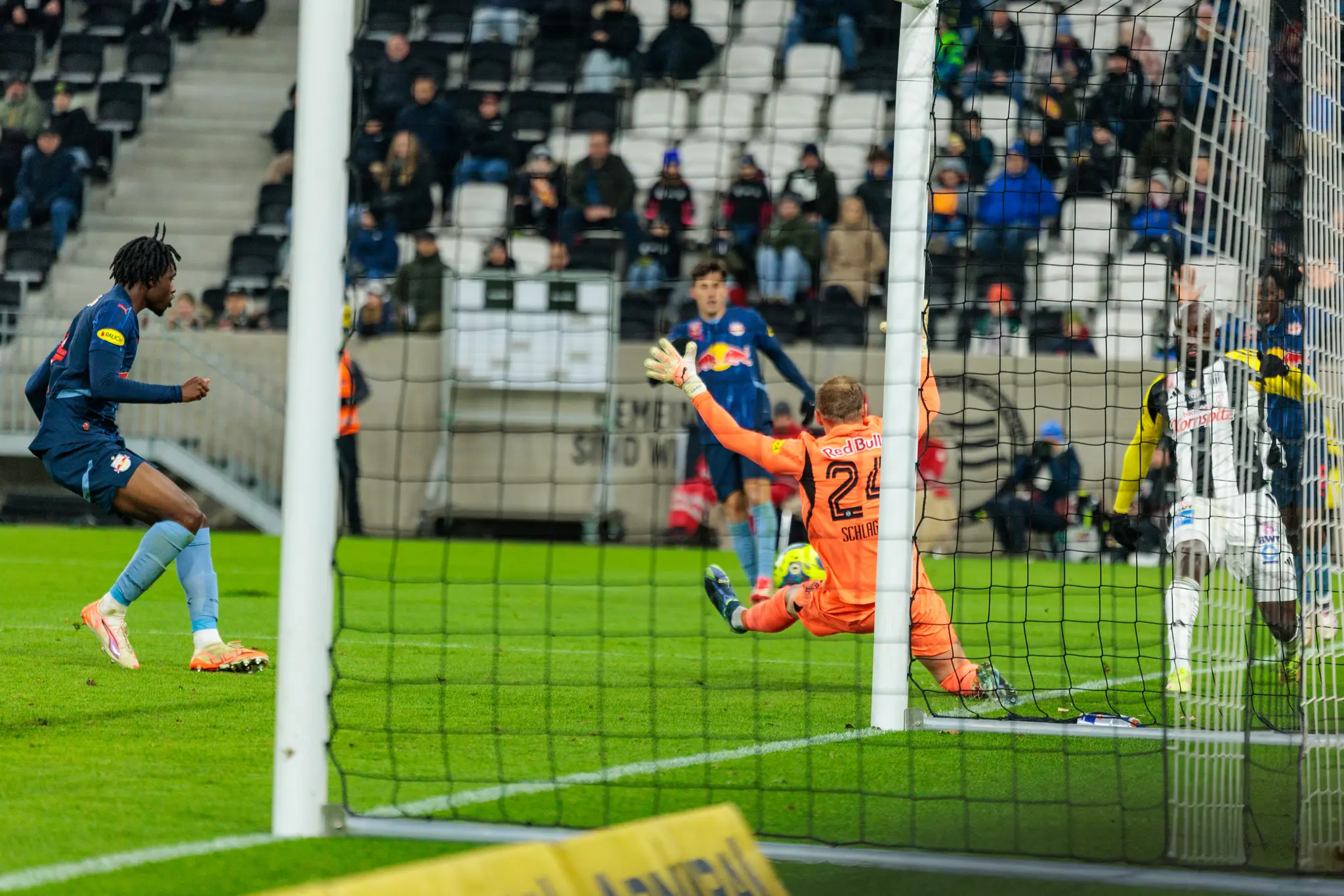 Fußballspiel im Stadion: LASK Spieler schießt auf das Tor, Red Bull Torwart versucht den Ball zu parieren 