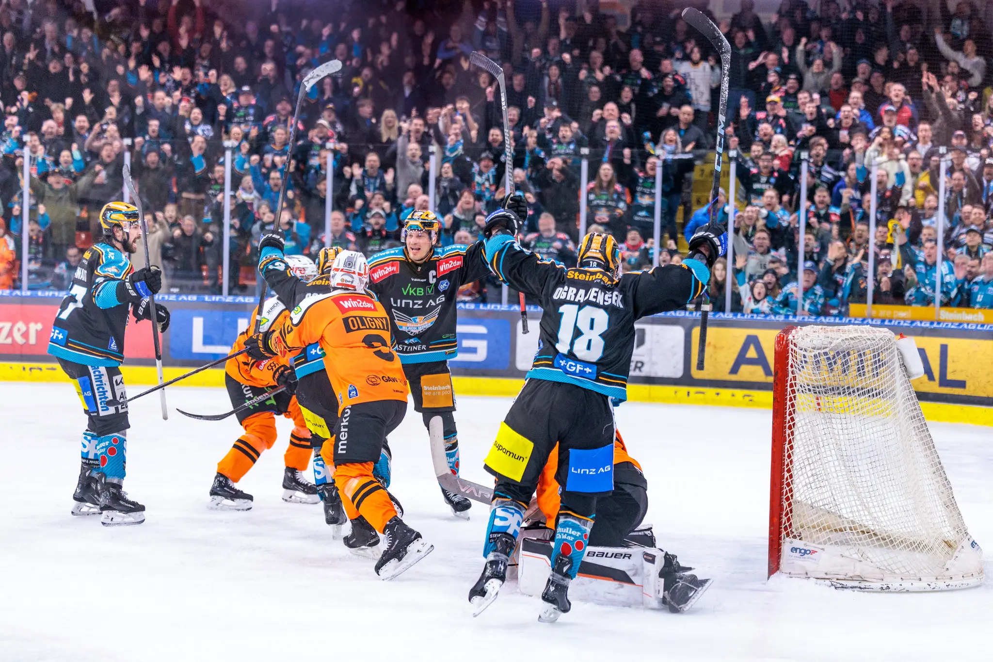 Eishockeyspieler der Black Wings Linz jubeln ausgelassen nach einem Tor auf dem Eis 
