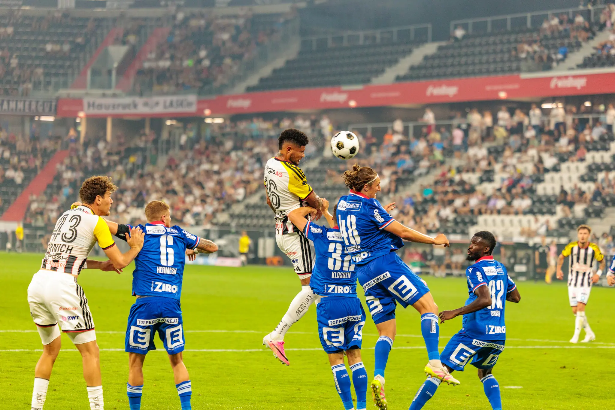 LASK-Spieler Danek gewinnt einen Kopfball im Luftzweikampf gegen drei GAK-Verteidiger im Strafraum