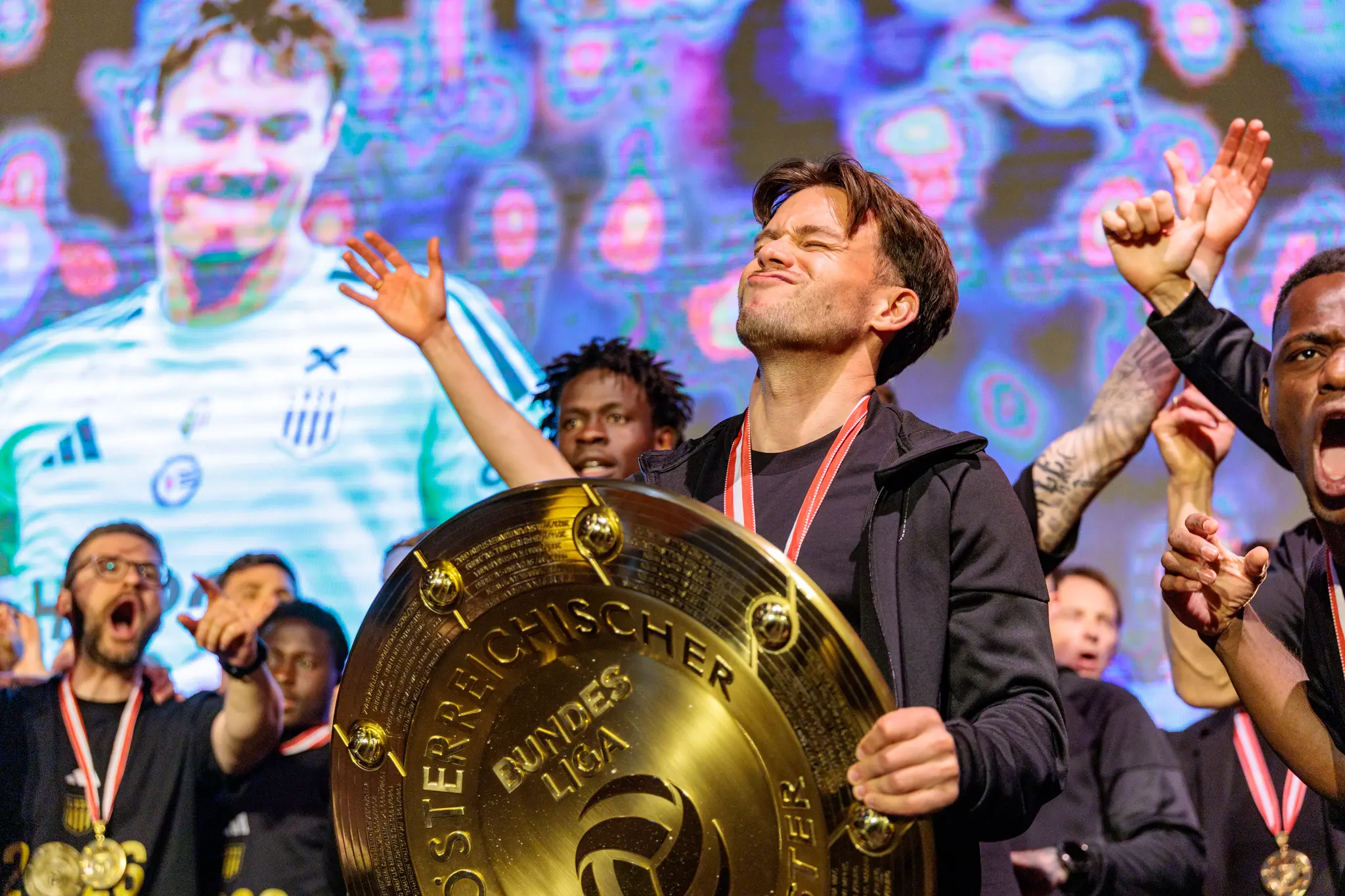 Ein stolzer LASK-Spieler präsentiert während der emotionalen Meisterfeier in Linz den goldenen Meisterteller