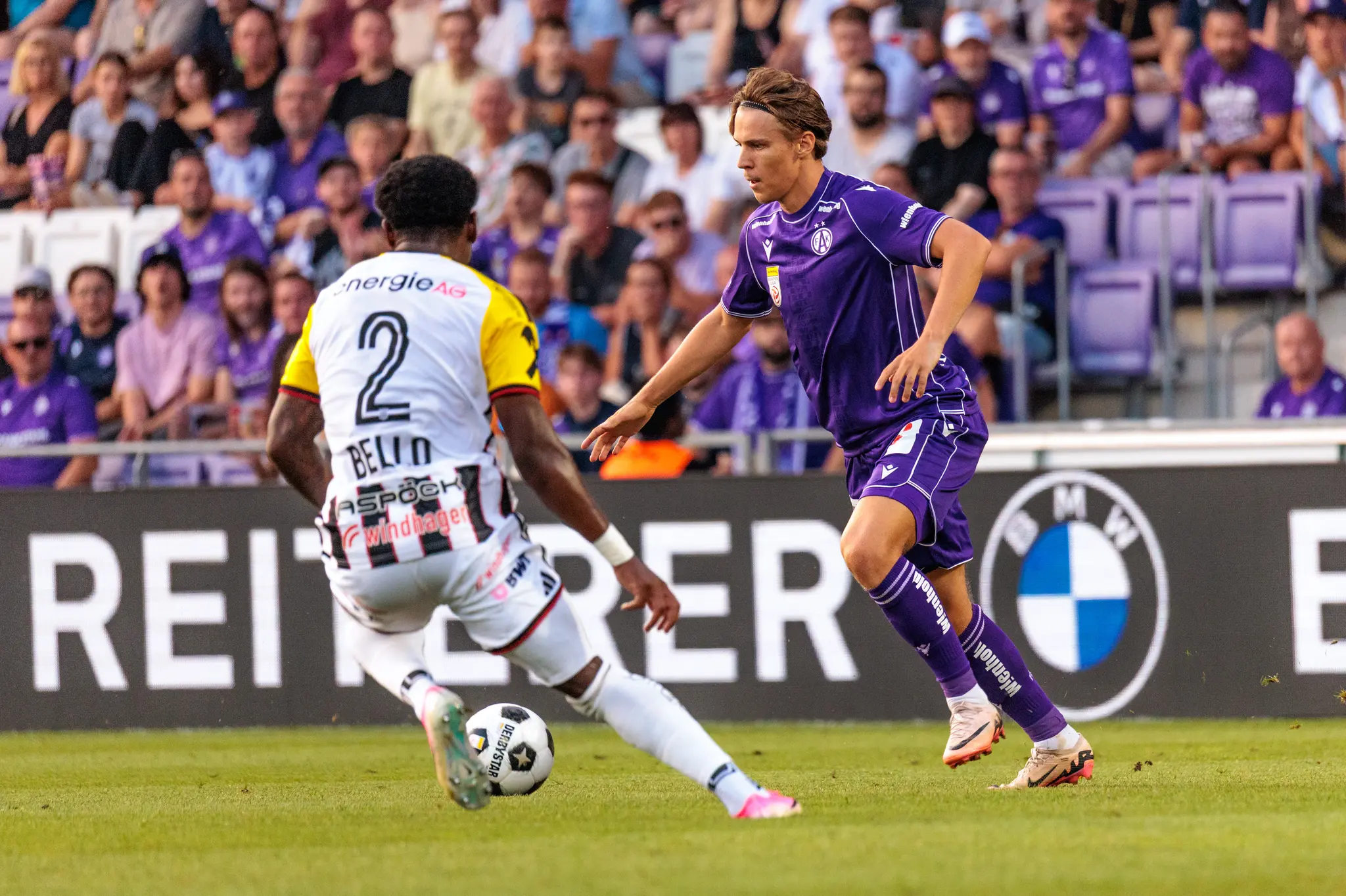 Austria-Spieler dribbelt am Flügel, LASK-Flügelspieler Bello stellt sich ihm entgegen