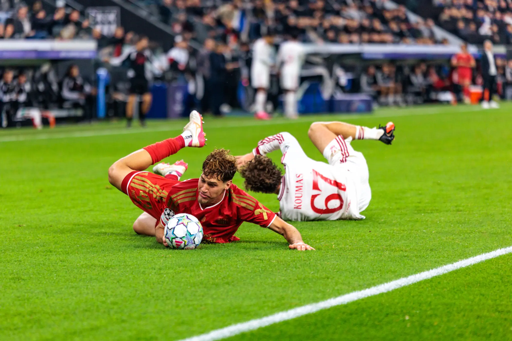 Tornich (43) liegt mit dem Ball unter sich am Boden, Koumas (67) geht im Zweikampf ebenfalls zu Boden.
