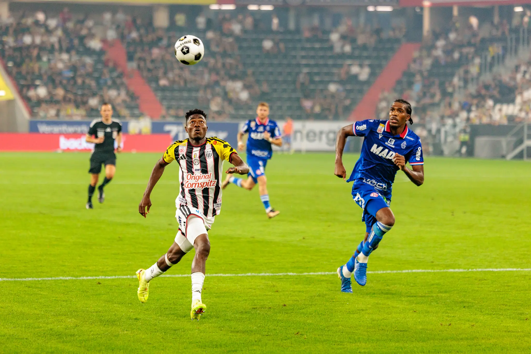 Moses Usor aus Nigeria kontrolliert den Ball mit dem Oberkörper im Angriff, während ein GAK-Verteidiger heranläuft
