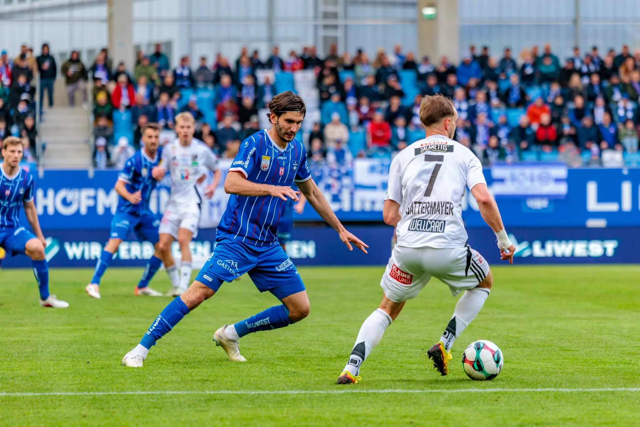 Ein Spieler des Wolfsberger AC führt eine Offensivaktion gegen einen Verteidiger des Blau-Weiß Linz aus