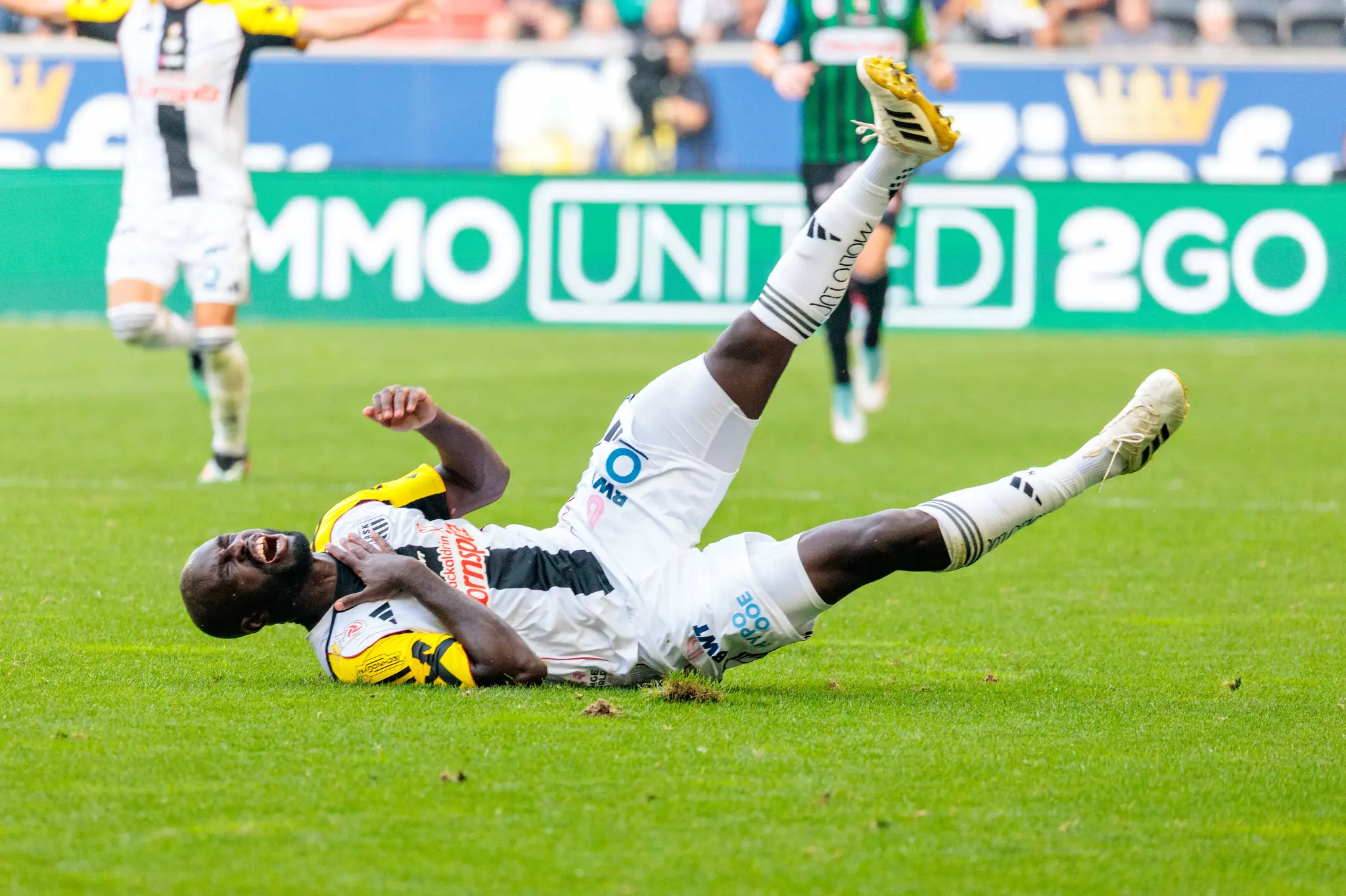 Ein LASK-Spieler in seinem weiß-schwarzen Trikot liegt mit schmerzverzerrtem Gesicht auf dem Rasen während eines Bundesliga-Spiels gegen SV Ried