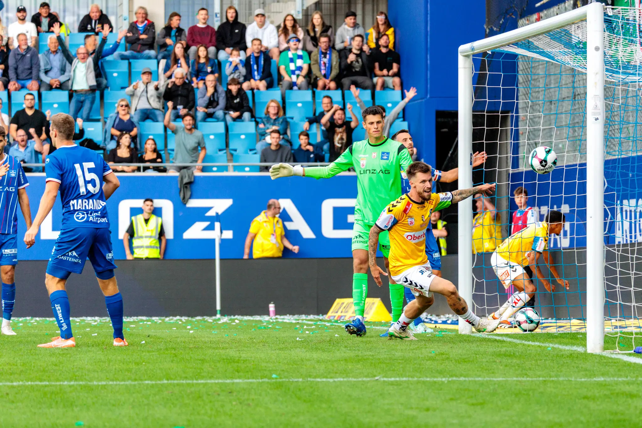 Der SV Ried Spieler Pomer jubelt ausgelassen über sein Tor zum 1:0 gegen Blau-Weiß Linz, der Ball ist im Netz und Fans feiern im Hintergrund