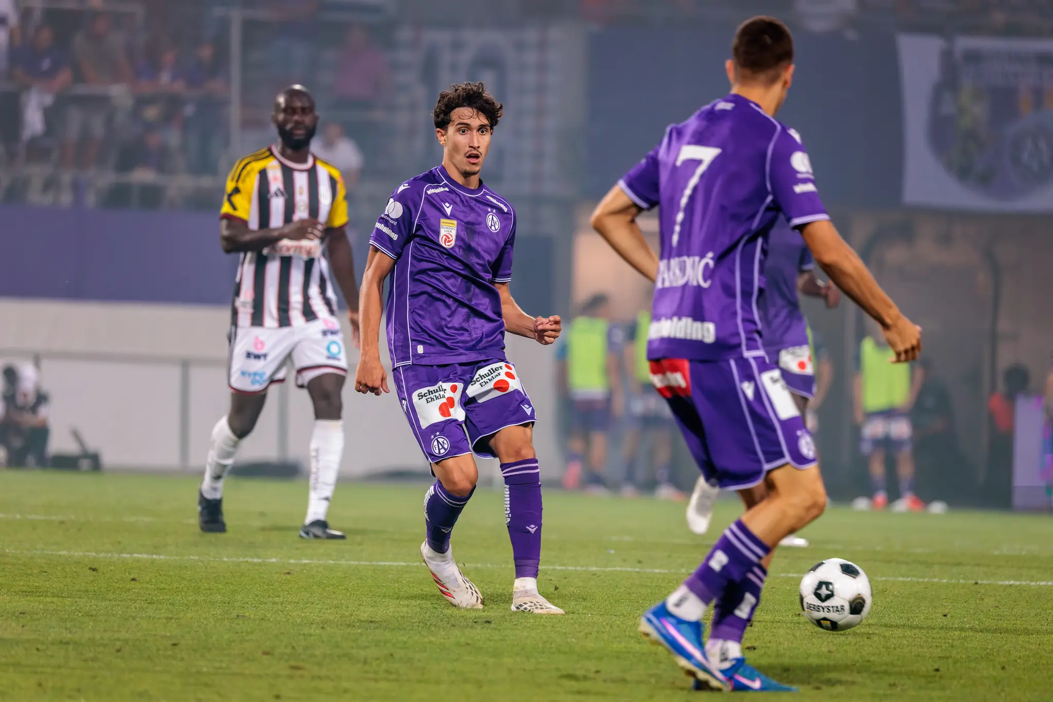 Austria-Spieler kontrolliert den Ball und blickt spielaufbauend nach vorne, ein LASK-Profi wartet dahinter