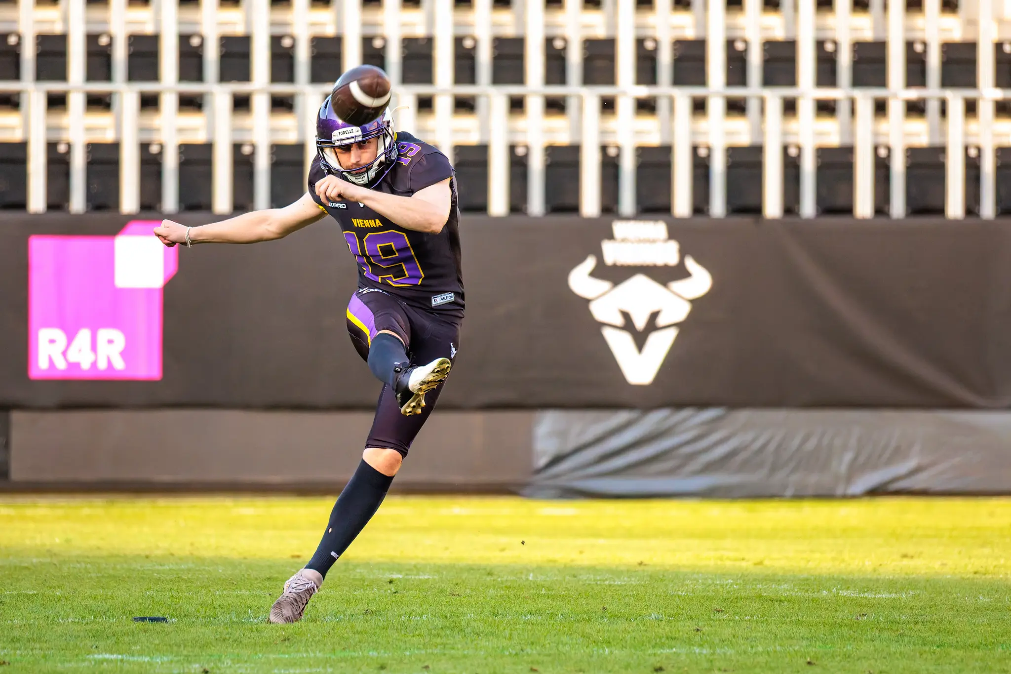Oskar Herz (19) schmettert den Punt ins Abendlicht, der Ball rotiert hoch über seinem Kopf – Special-Teams-Arbeit der Vienna Vikings im Heimstadion gegen die Firenze Red Lions.