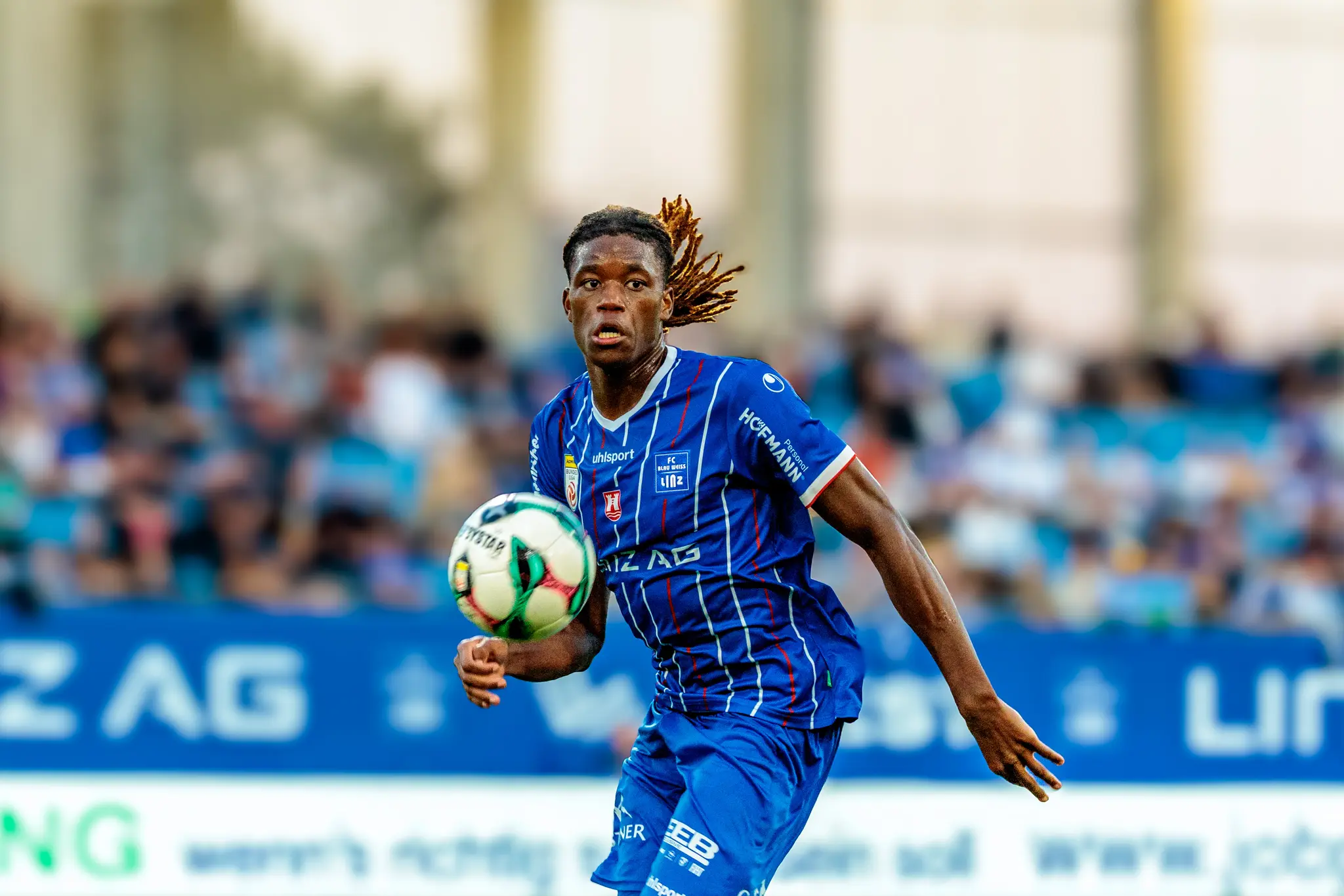 Der Fußballspieler Mamadou Fofana vom FC Blau-Weiß Linz kontrolliert den Ball während des Bundesligaspiels mit konzentriertem Gesichtsausdruck