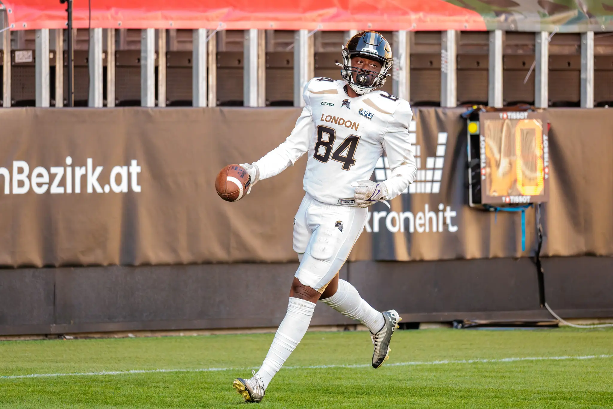 Gleicher Moment, gleiche Nummer: London-Spieler Nr. 84 trabt mit dem Ball über den Rasen und feiert seinen Touchdown – Jubel nach dem Passfang am Pylon.