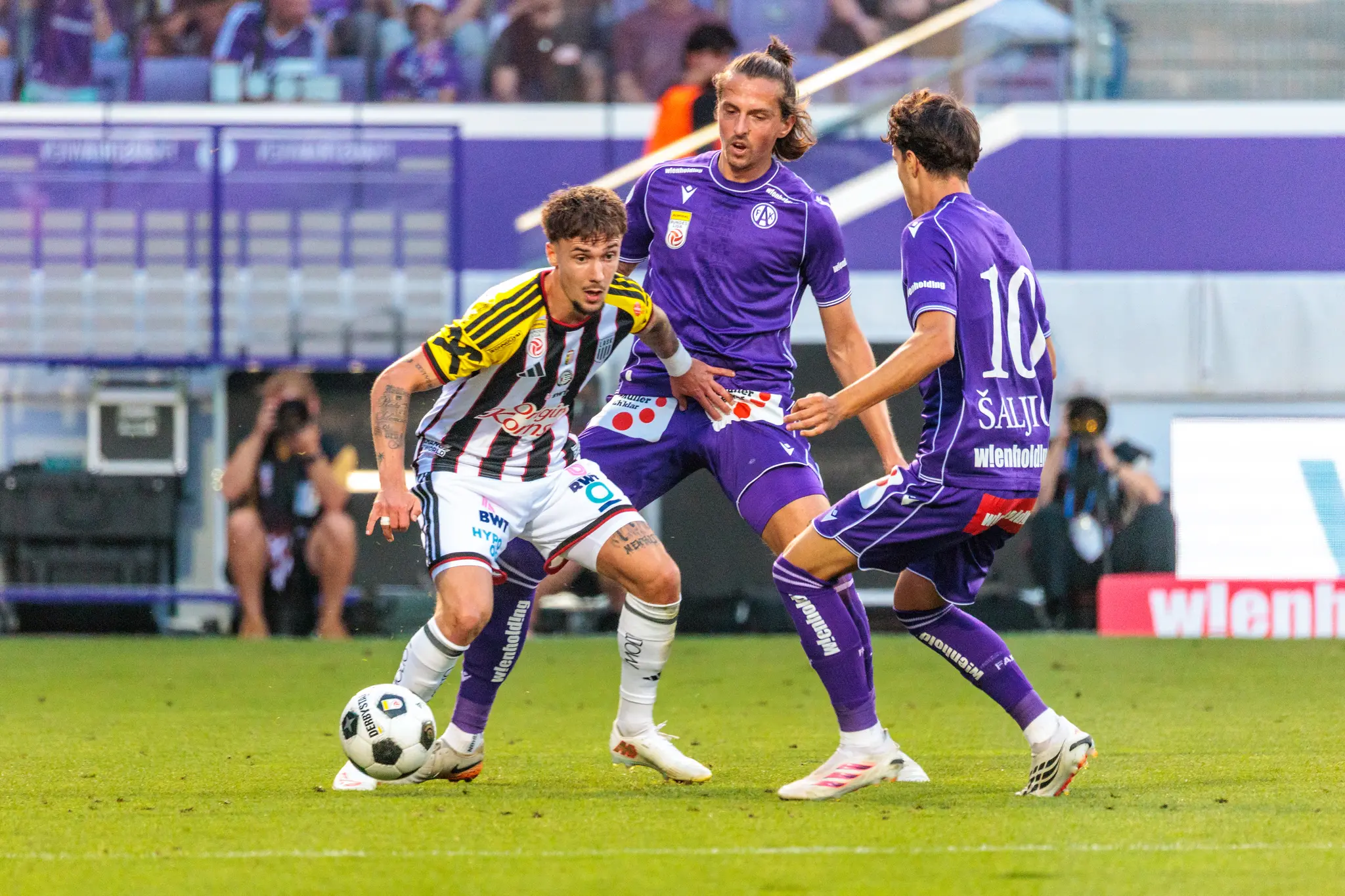 LASK-Spieler dribbelt den Ball, Austria-Stürmer Saljic greift im Pressing-Zweikampf ein