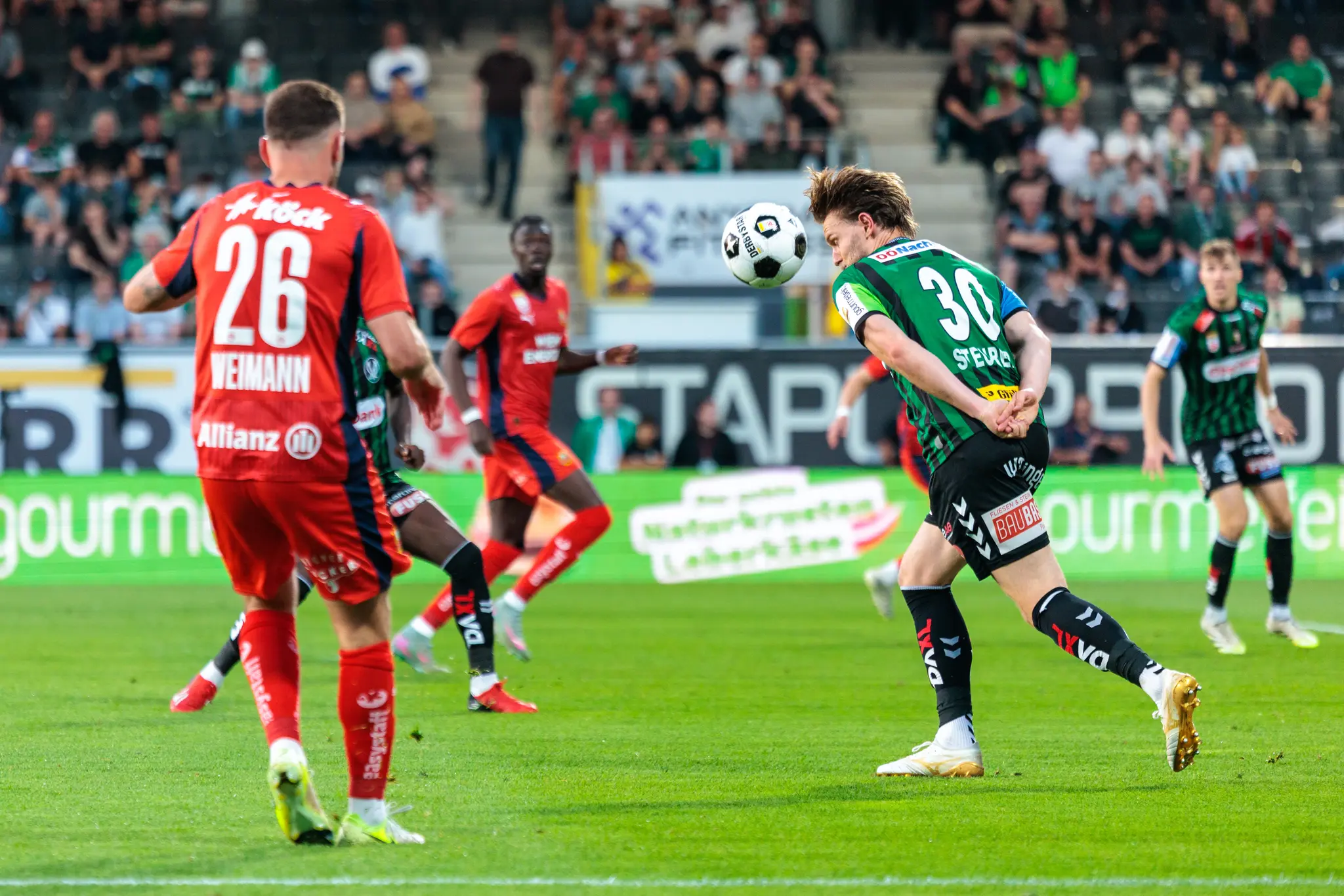 Ein Spieler der SV Ried köpft den Ball während des Bundesliga-Playoff-Spiels gegen Rapid Wien