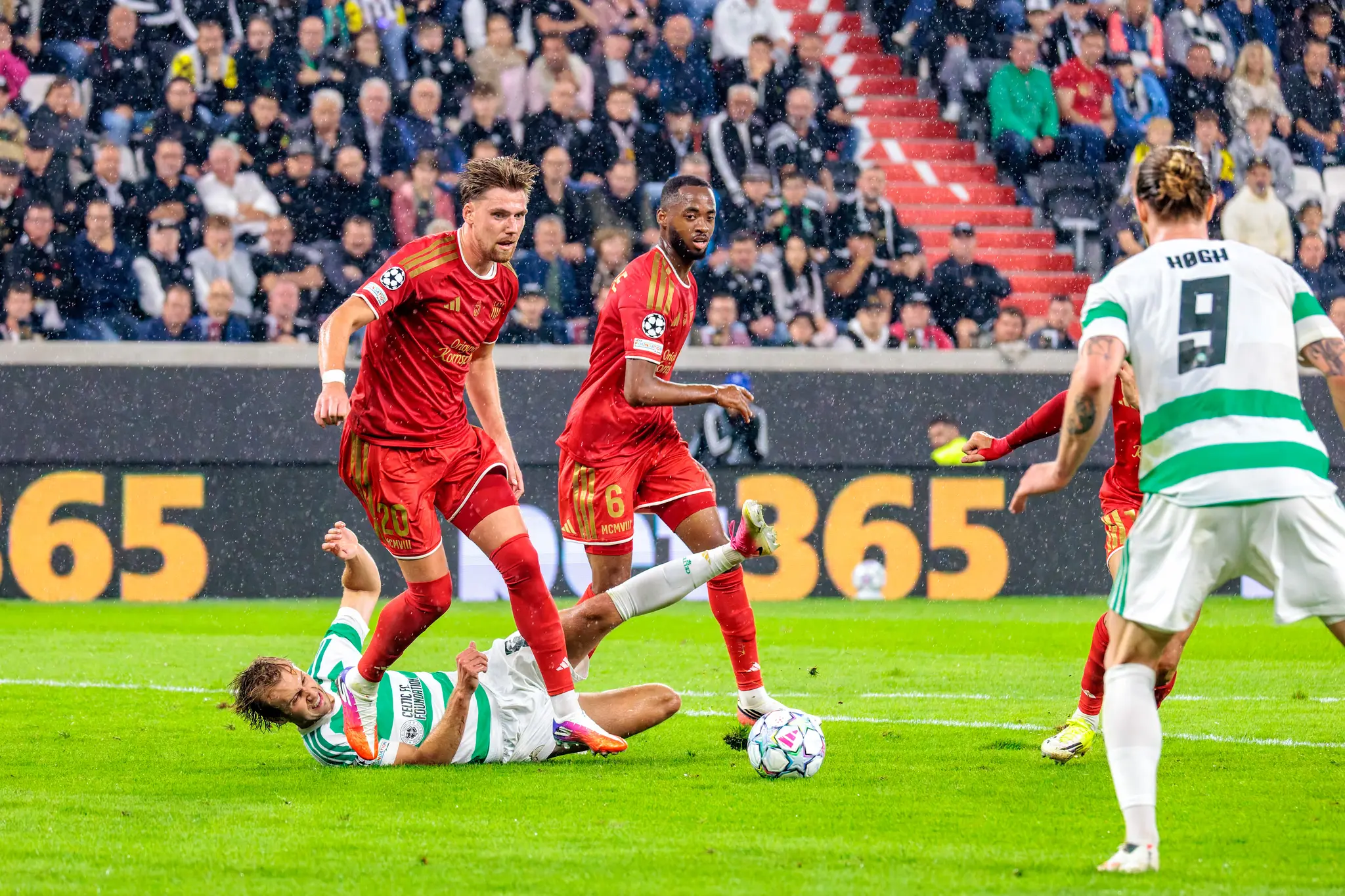 Celtic-Akteur liegt nach dem Zweikampf am Boden, während LASKs Jörgensen (20) den Ball behauptet, Bogarde (6) absichert und Högh (9) die Szene beobachtet.
