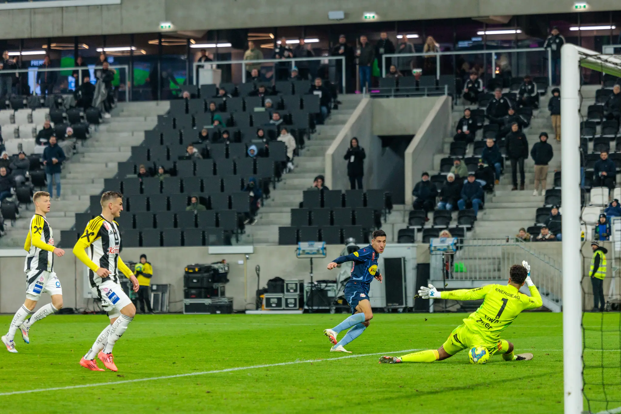 Fußballspiel im Stadion: Spieler schießt auf Tor, Torwart hat ein Gurkerl bekommen 