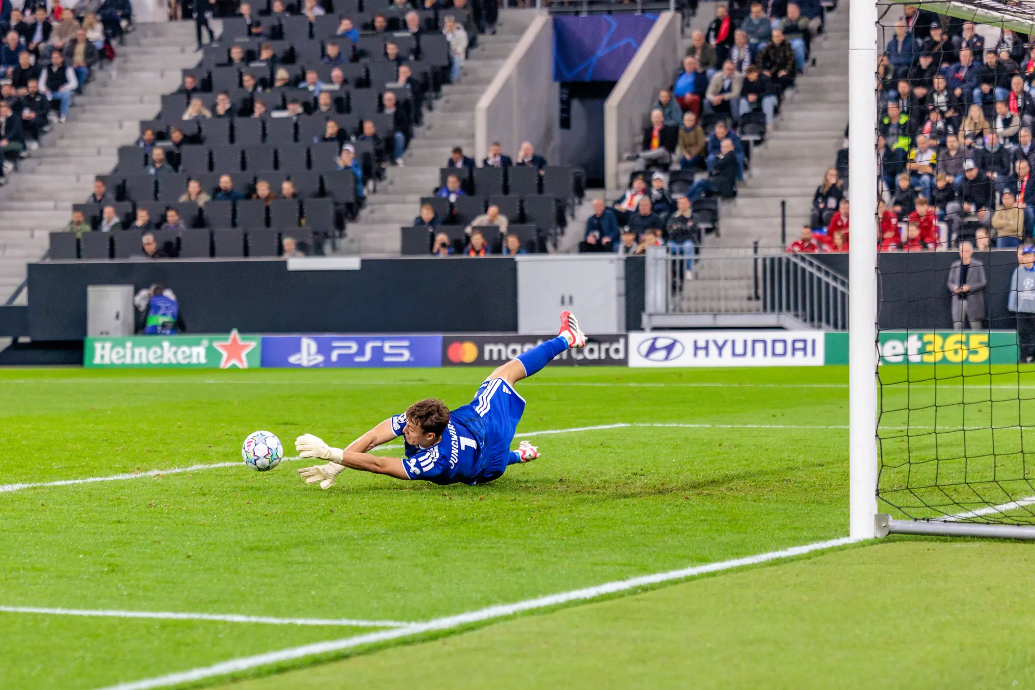 LASK-Torwart Lukas Jungwirth (1) wirft sich in einer seitlichen Grätsche dem Ball kurz vor der Torlinie hinterher.