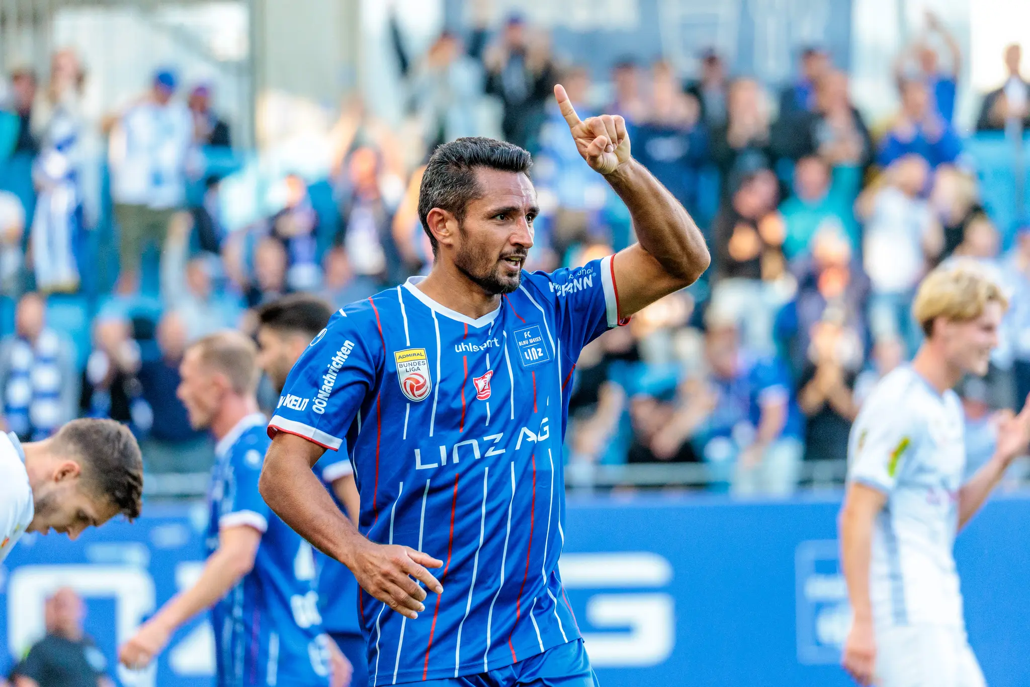 Der Torschütze Ronivaldo vom FC Blau-Weiß Linz jubelt im blau-weiß gestreiften Trikot und reckt nach seinem Tor den Zeigefinger in die Luft