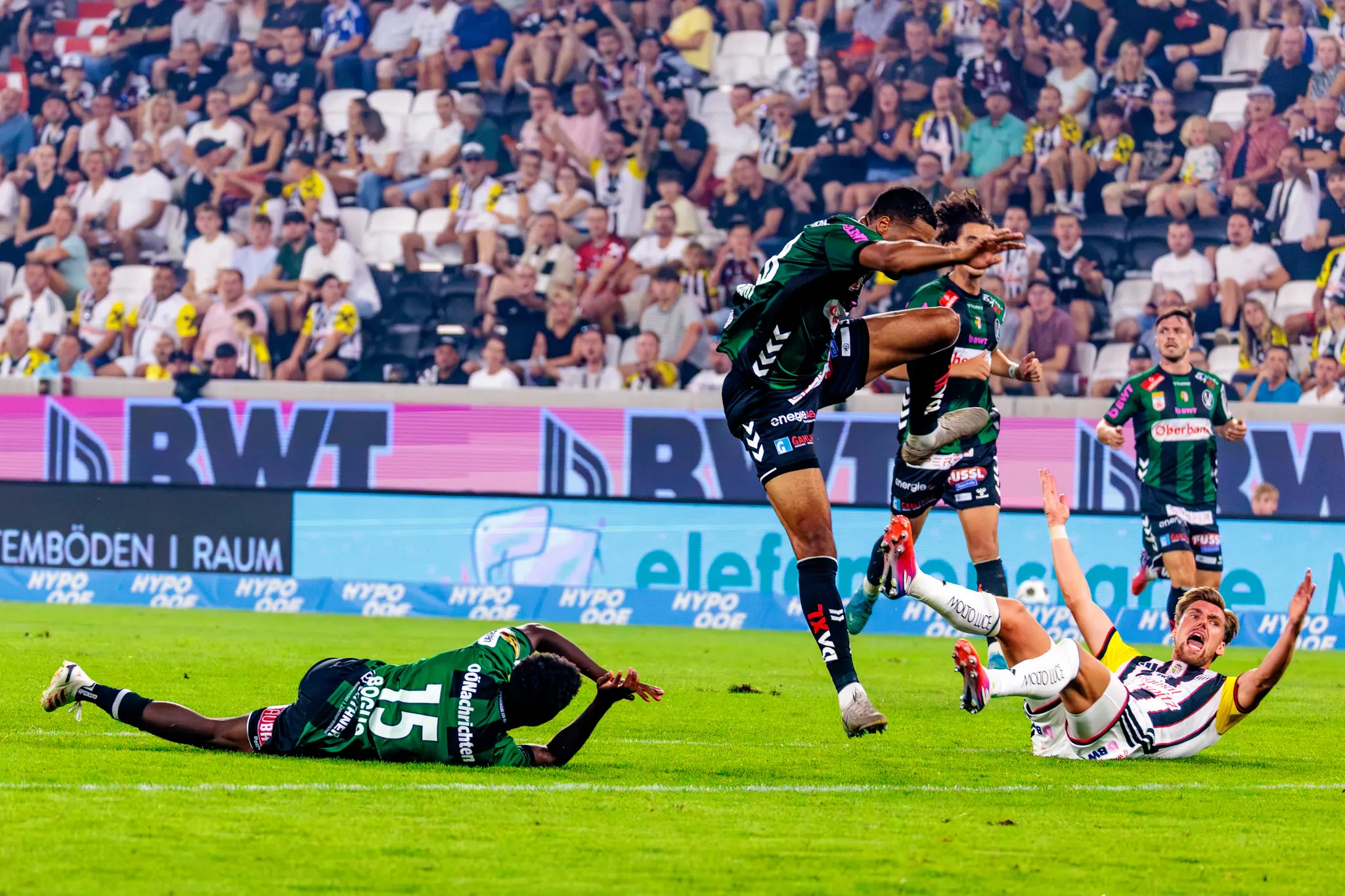 Nach hartem Zweikampf liegen Rieder Boguo (Nr. 15) und ein LASK-Spieler am Rasen