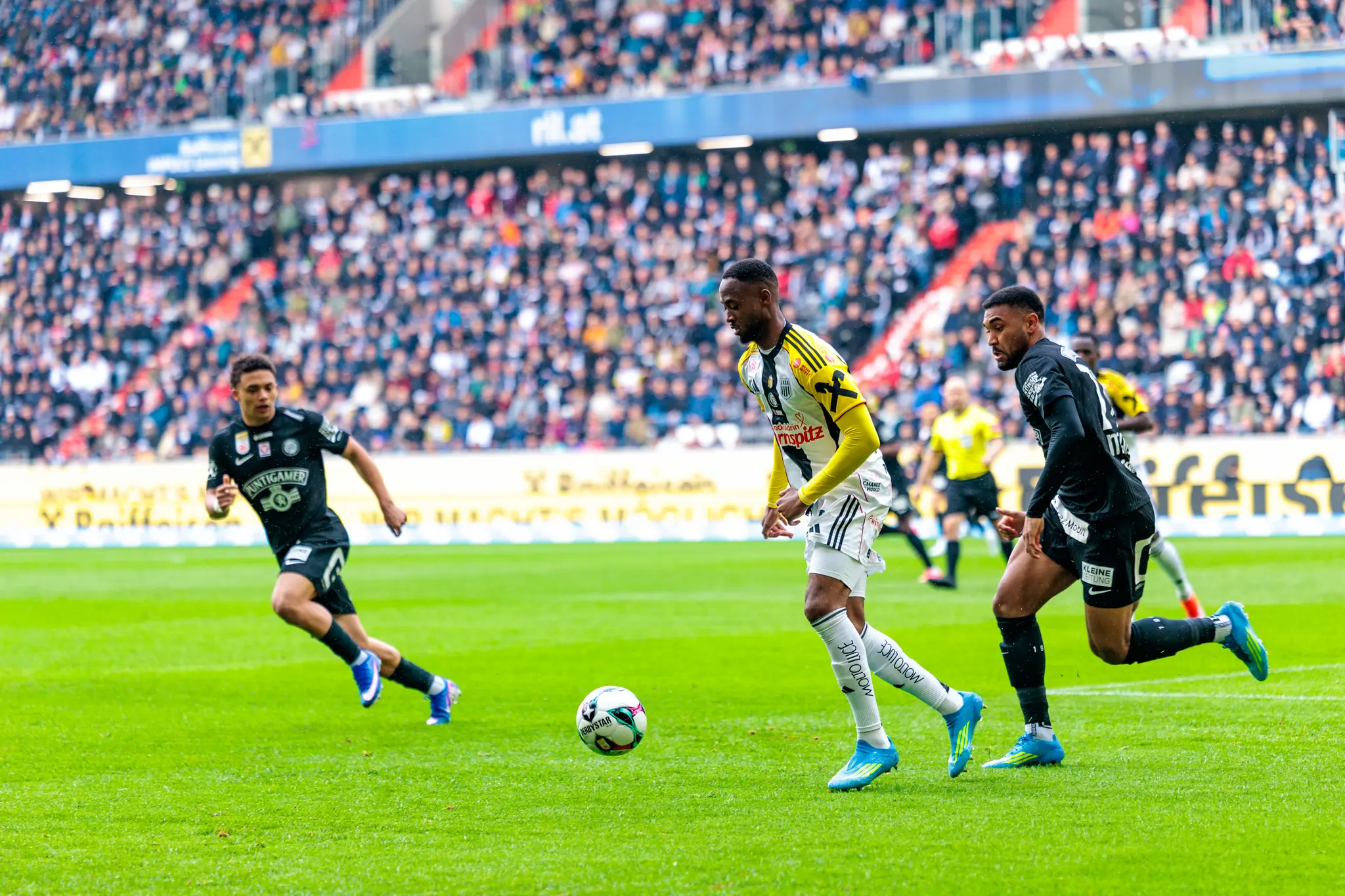 Ein LASK-Spieler dribbelt den Ball gegen einen Verteidiger von Sturm Graz