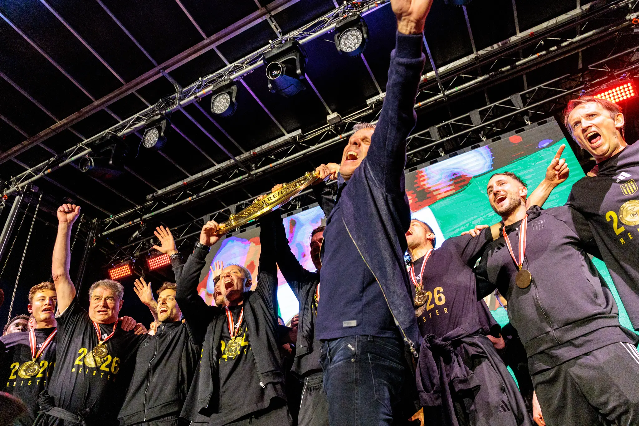 Das Trainerteam des LASK reckt die Trophäe während der emotionalen Meisterfeier in Linz hoch