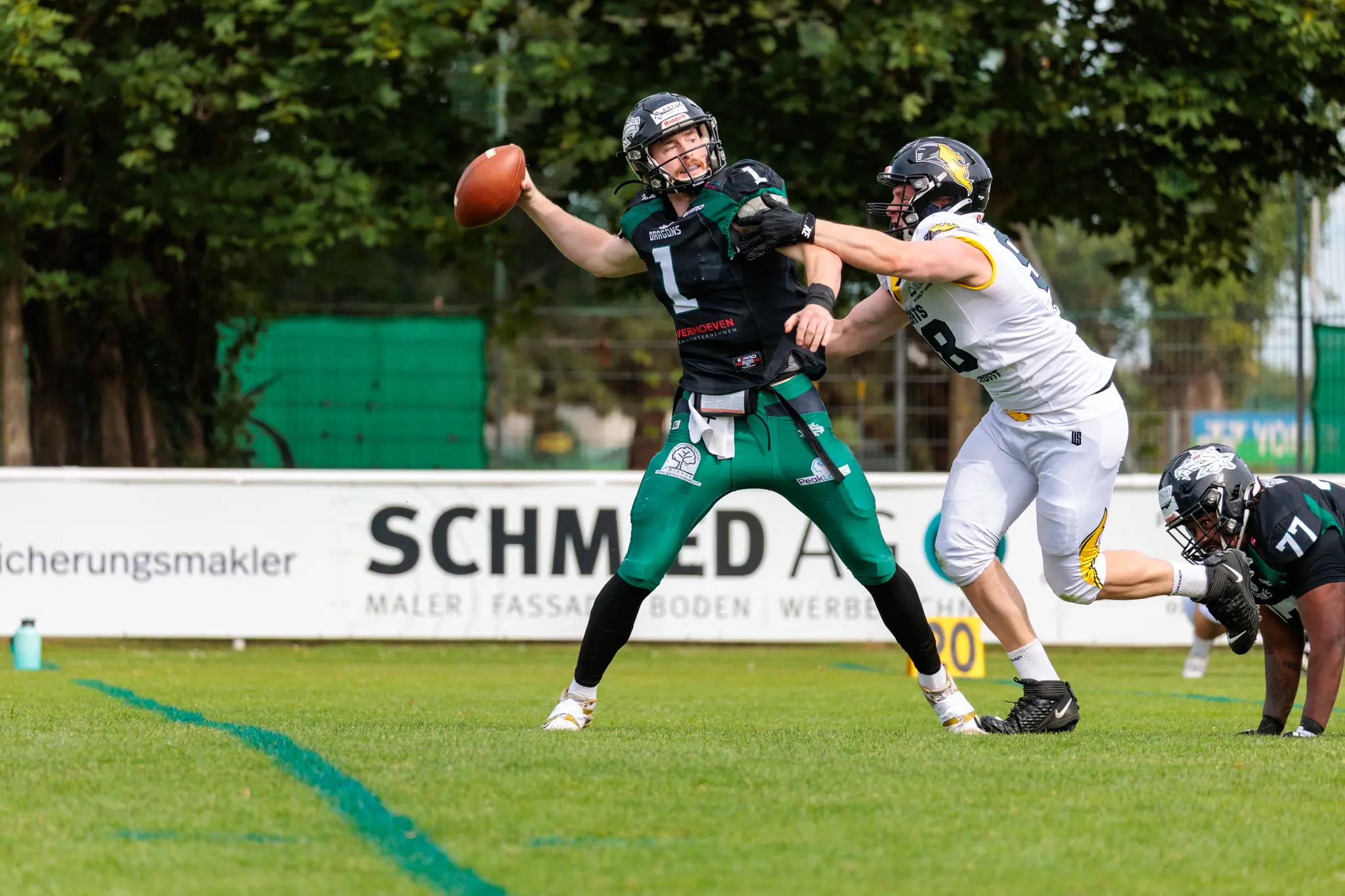 Ein Quarterback der Danube Dragons wird während eines Spiels gegen die Vienna Knights in der Pocket von einem Verteidiger bedrängt