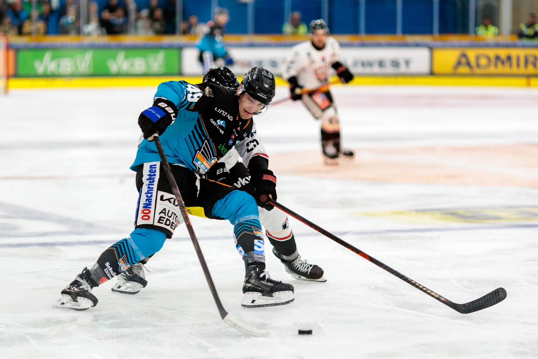 Eishockeyspieler Patrick Söllinger von den Steinbach Black Wings Linz im Zweikampf um den Puck auf dem Eis während eines Spiels