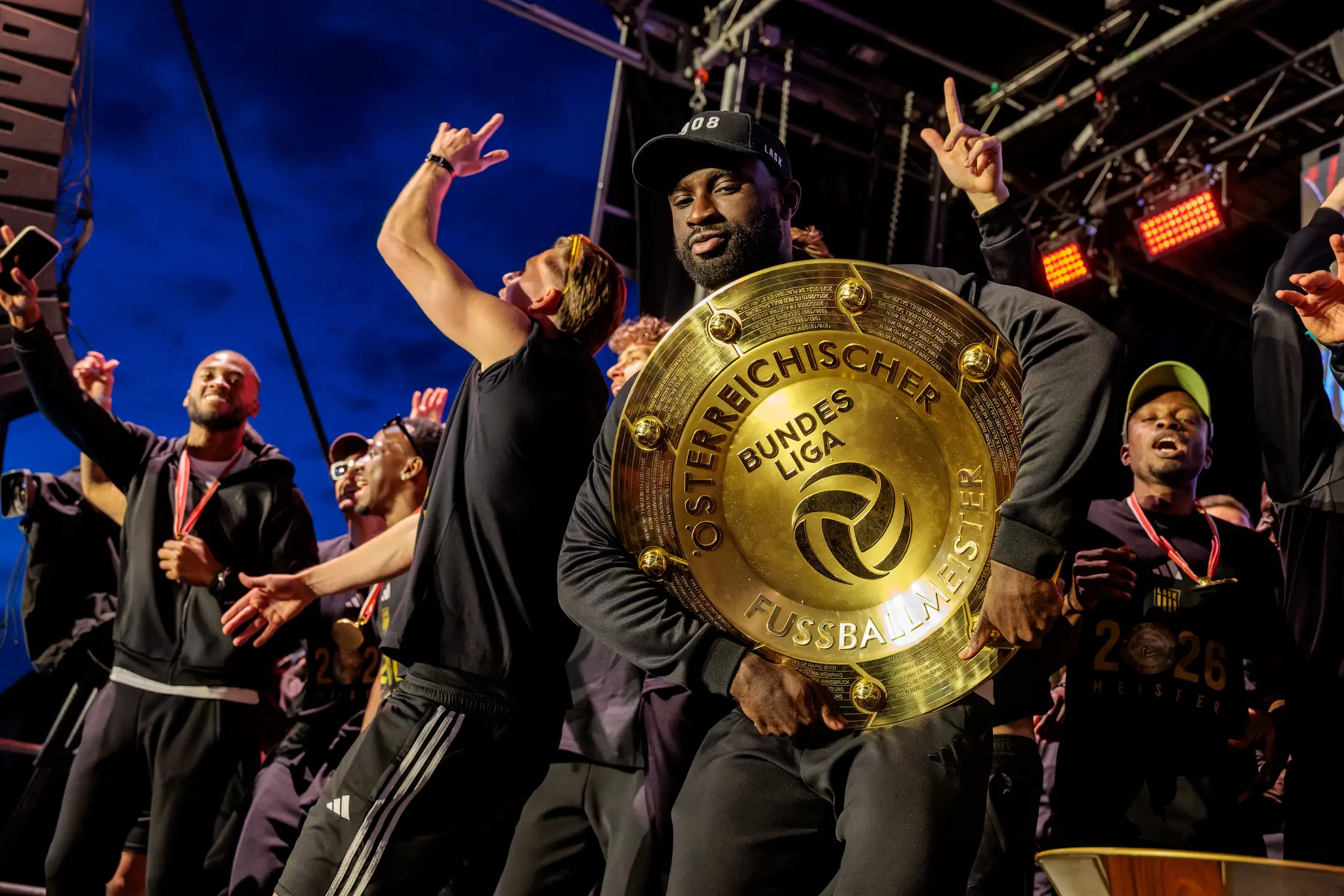 Ein stolzer LASK-Spieler präsentiert den goldenen Meisterteller während der emotionalen Siegerehrung in Linz