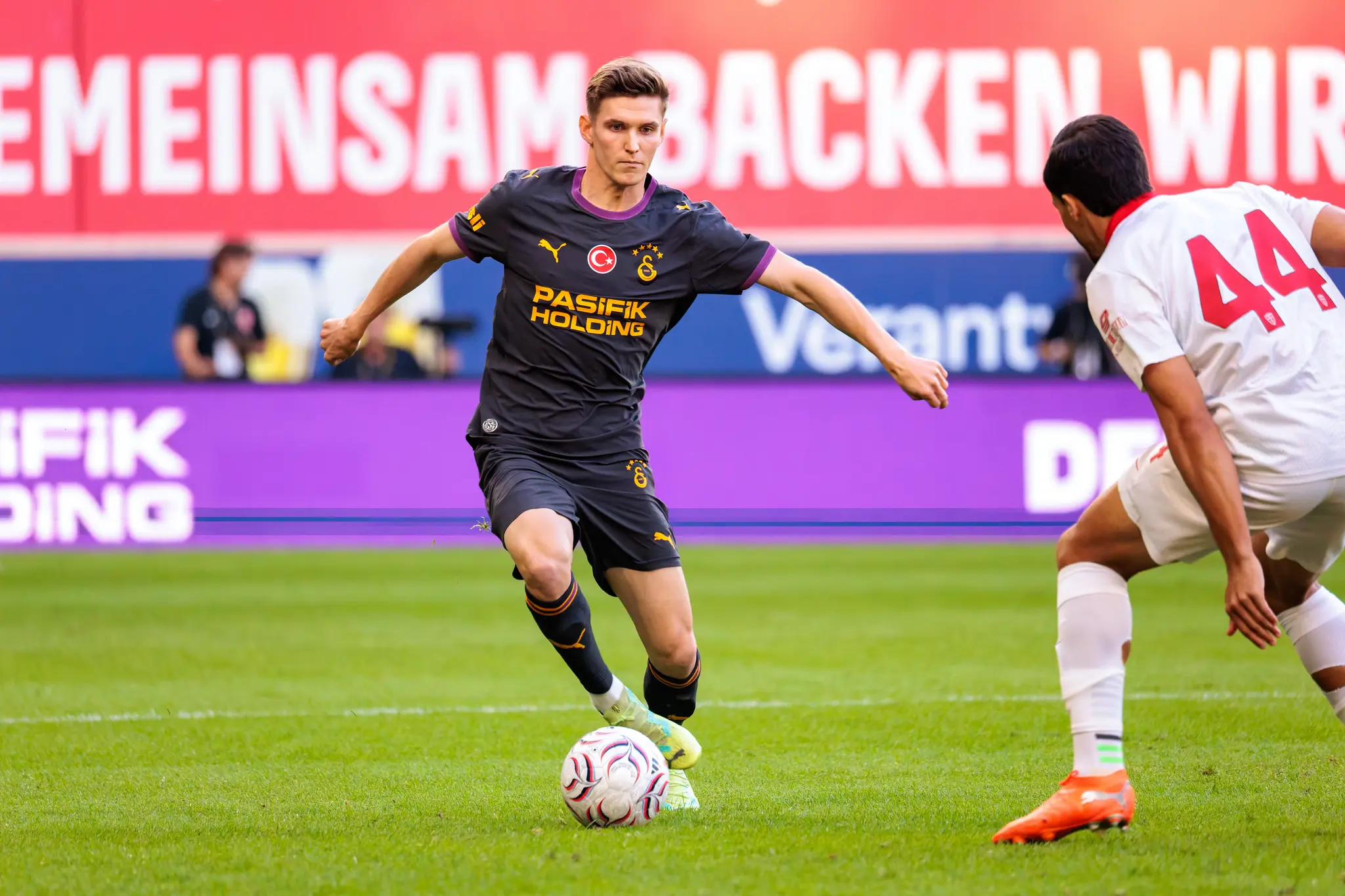 Galatasaray-Spieler kontrolliert den Ball, Monza-Spieler Nummer 44 versucht von rechts zu blocken.