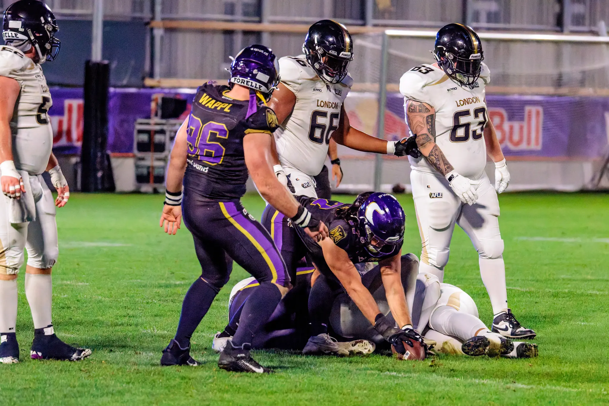 Marvin Wappl (96) der Vienna Vikings steht über dem Ball, nachdem ein Teamkollege den Fumble erzwungen hat – umringt von London-Spielern (66, 63) sichert Wien den Ball.