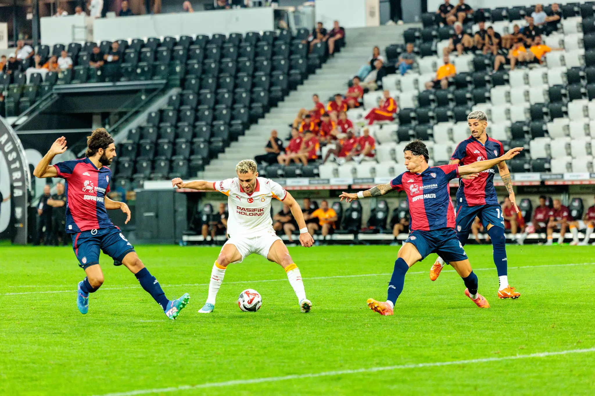 Drei Fußballspieler von Cagliari und Galatasaray kämpfen während eines Spiels der Nero Summer Series im Stadion um den Ball 