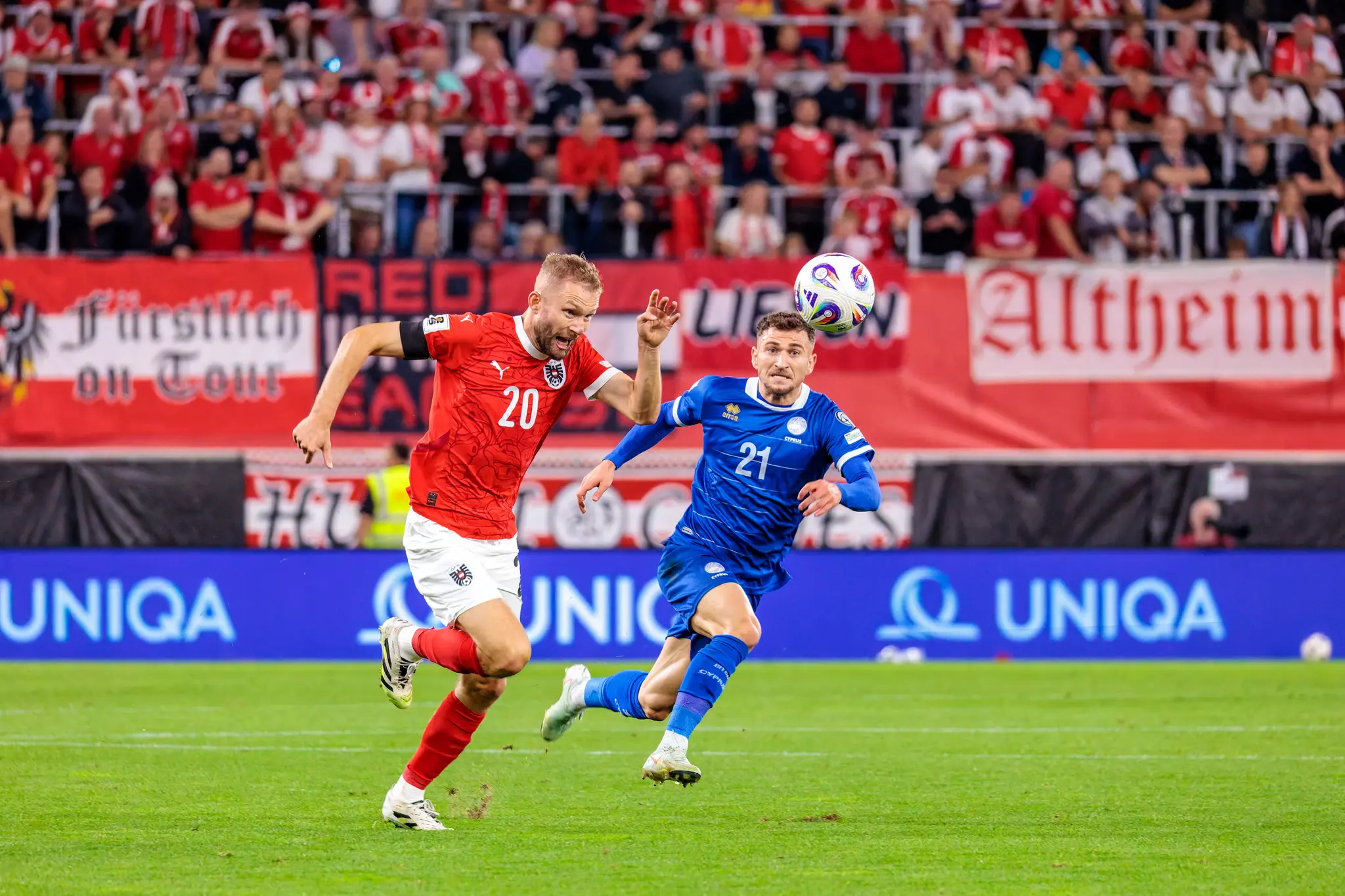 Konrad Laimer im österreichischen Trikot und Marinos Tzionis im zypriotischen Trikot in einem Laufduell um den Ball