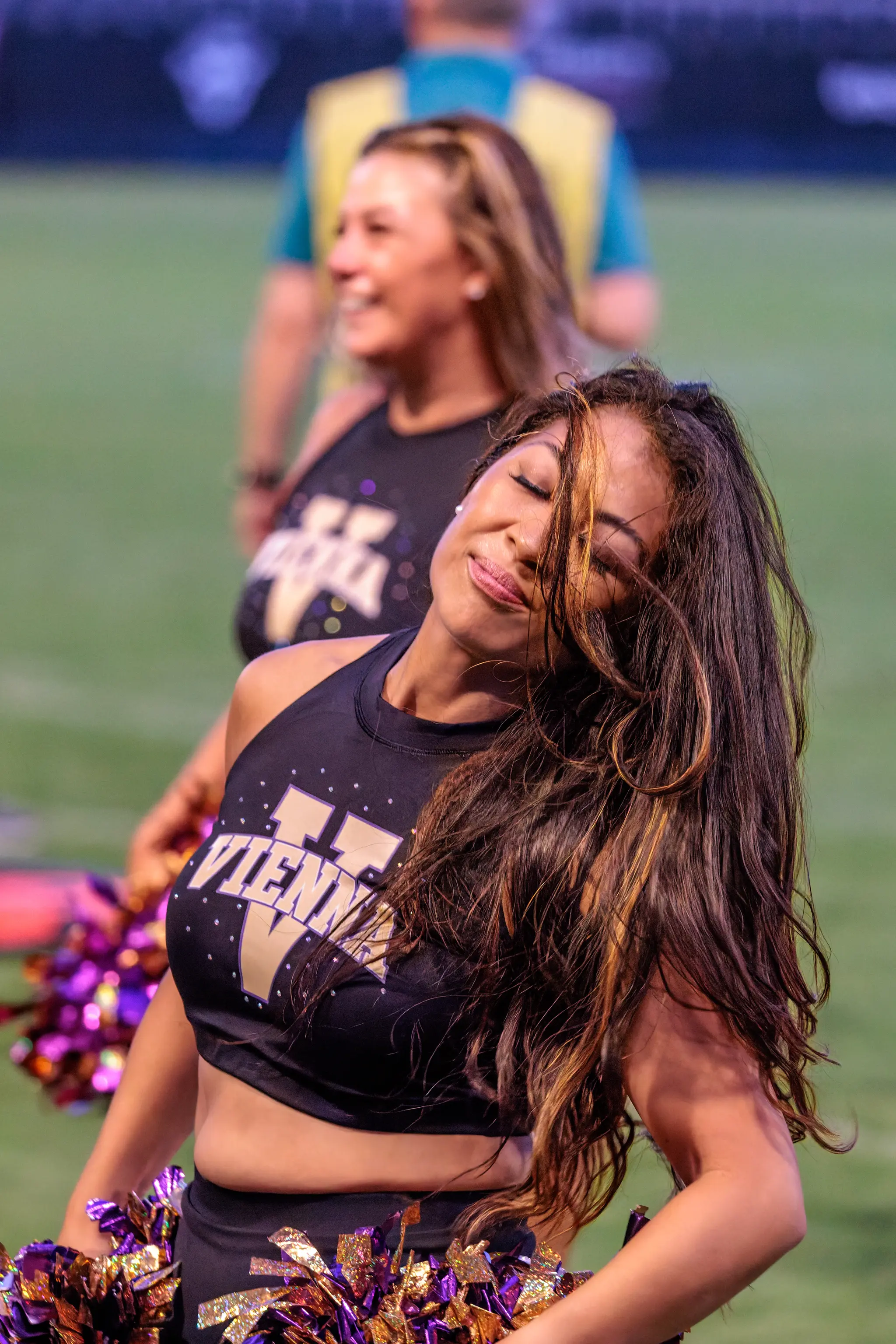 Mit geschlossenen Augen und wehender Mähne wirft sich eine Tänzerin des Vienna Vikings Spirit Squad in ihren Tanz, hinter ihr lacht die Kollegin – Showeinlage zwischen den Plays gegen die Red Lions.