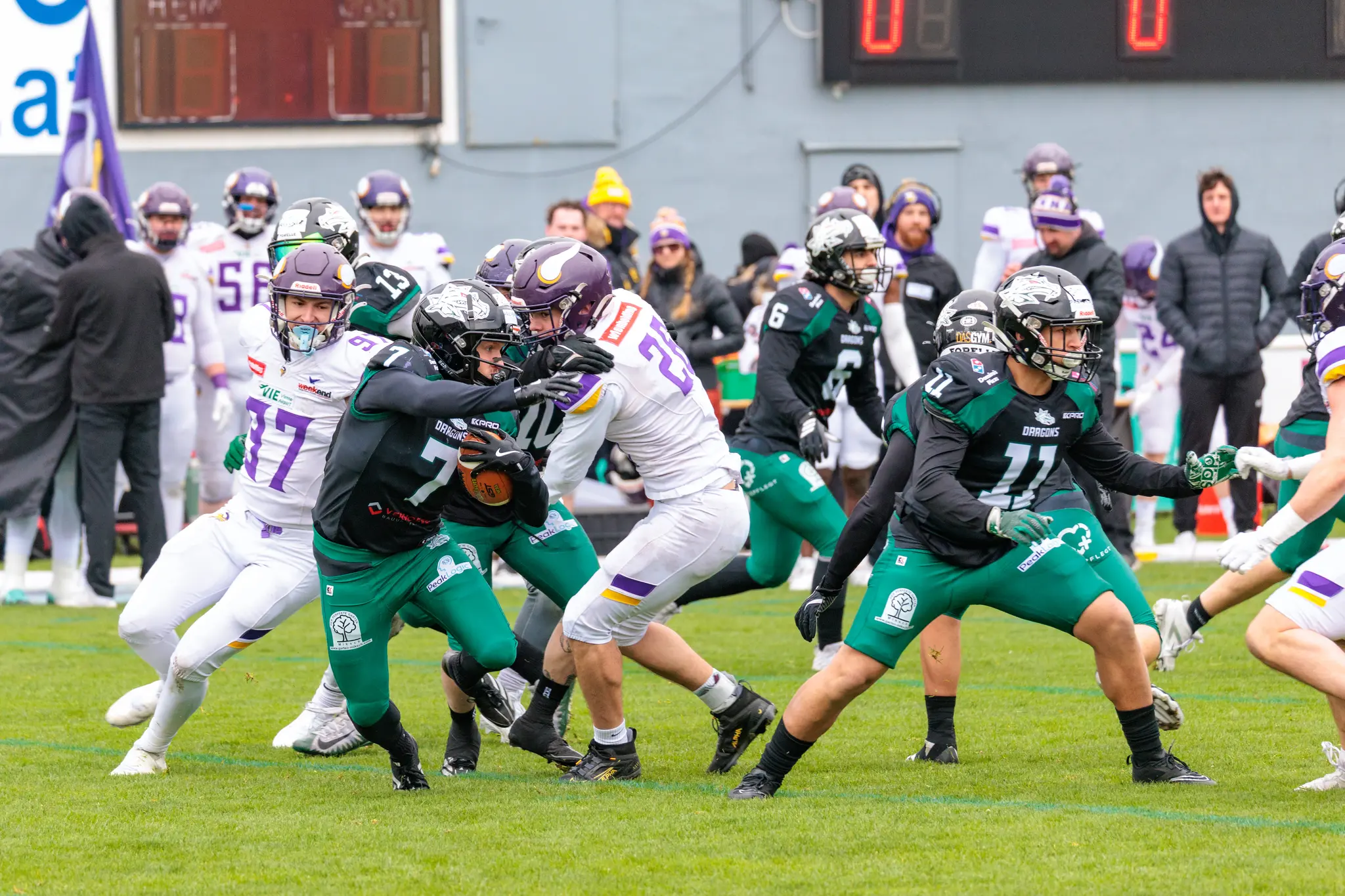 Ein American Football-Spieler der Danube Dragons läuft mit dem Ball inmitten von Gegenspielern der Vienna Vikings