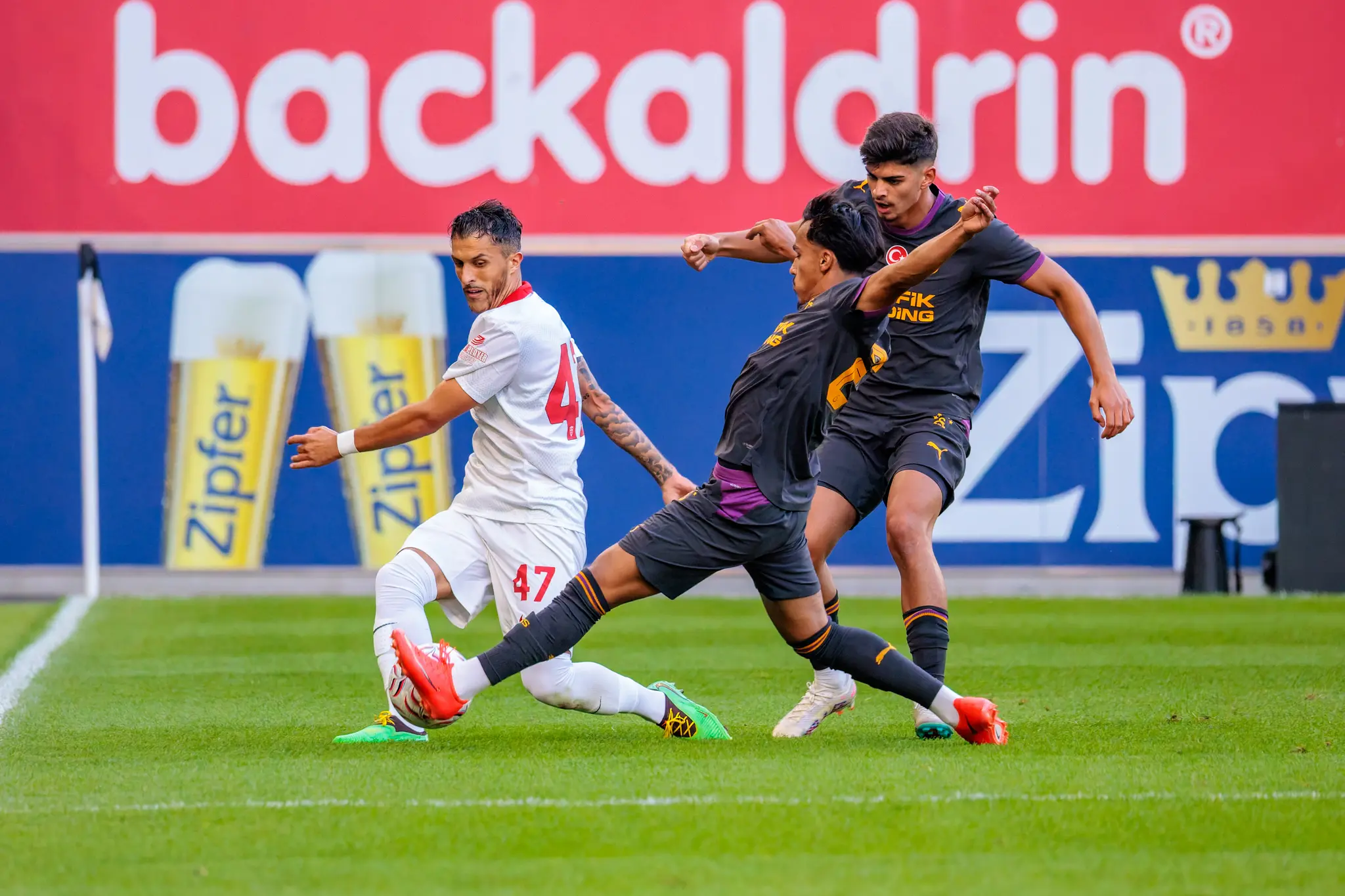 Drei Spieler im Duell: Monza-Spieler Nummer 47 wird von zwei Galatasaray-Spielern an der Sideline bedrängt.