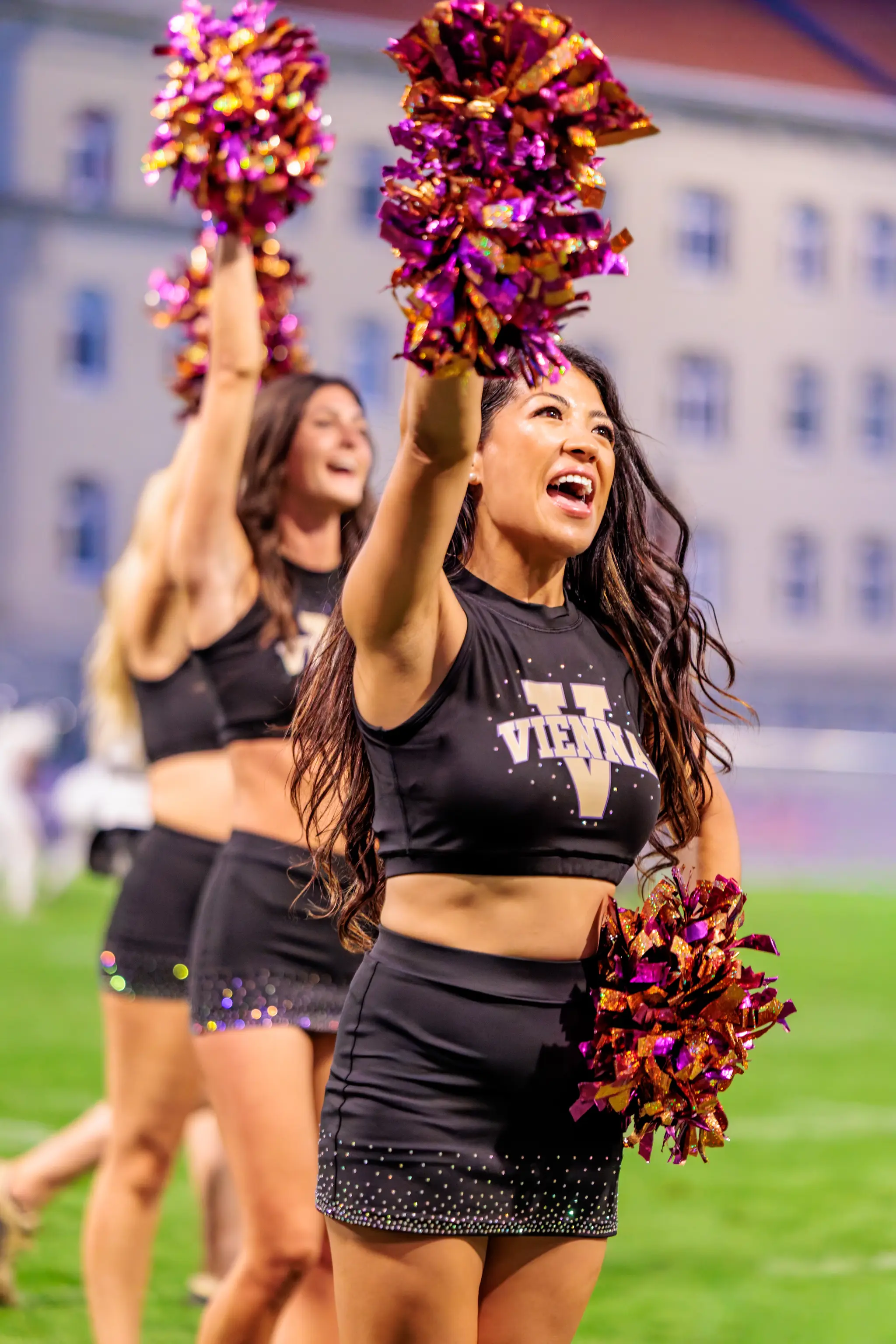 Mitten in der Choreografie: Eine Tänzerin des Vienna Vikings Cheer Squads ruft mit erhobenem Arm in die Menge, die Kolleginnen hinter ihr ziehen mit – Showeinlage bei der Pause.