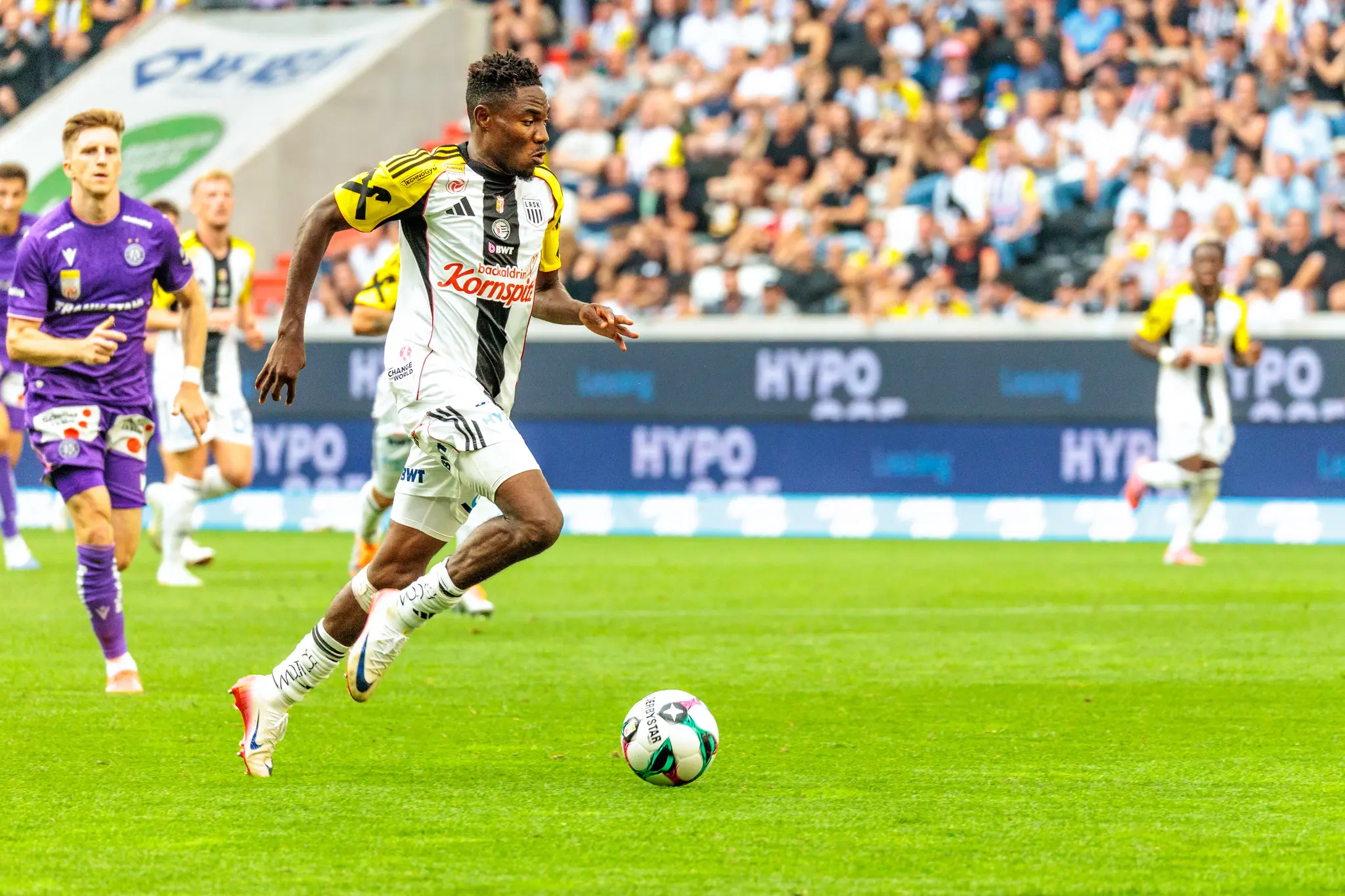 LASK-Spieler Moses Usor dribbelt in einem dynamischen Moment den Ball während eines Bundesliga-Spiels gegen Austria Wien