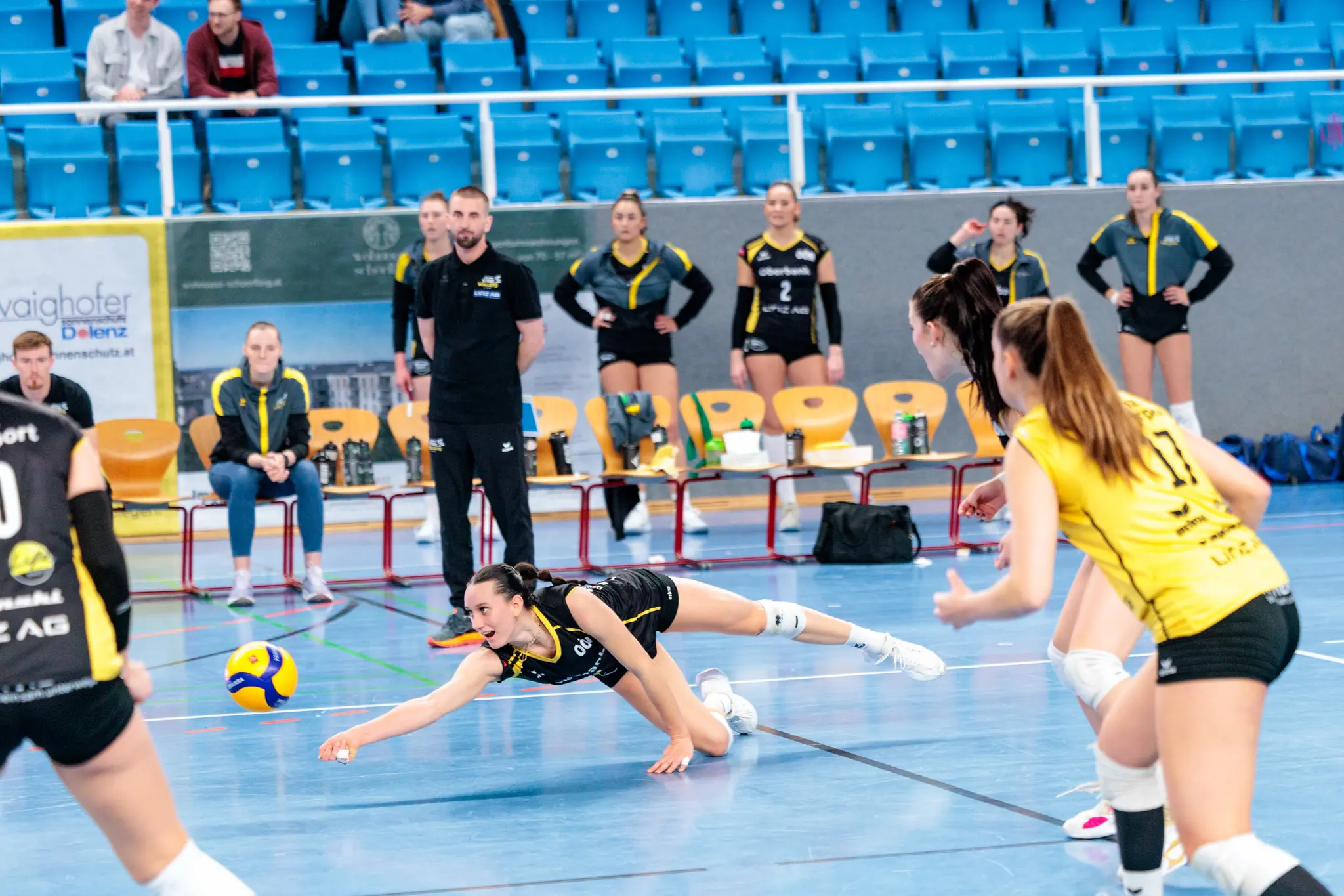 Volleyballspielerin hechtet nach dem Ball auf dem Spielfeld