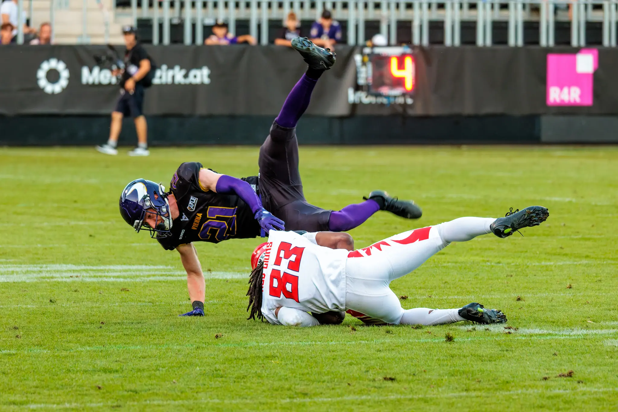 Spektakuläres Tackle: Leonhard Gerner (21) überschlägt sich über den Red-Lions-Receiver (83), der den Ball am Boden fest umklammert.