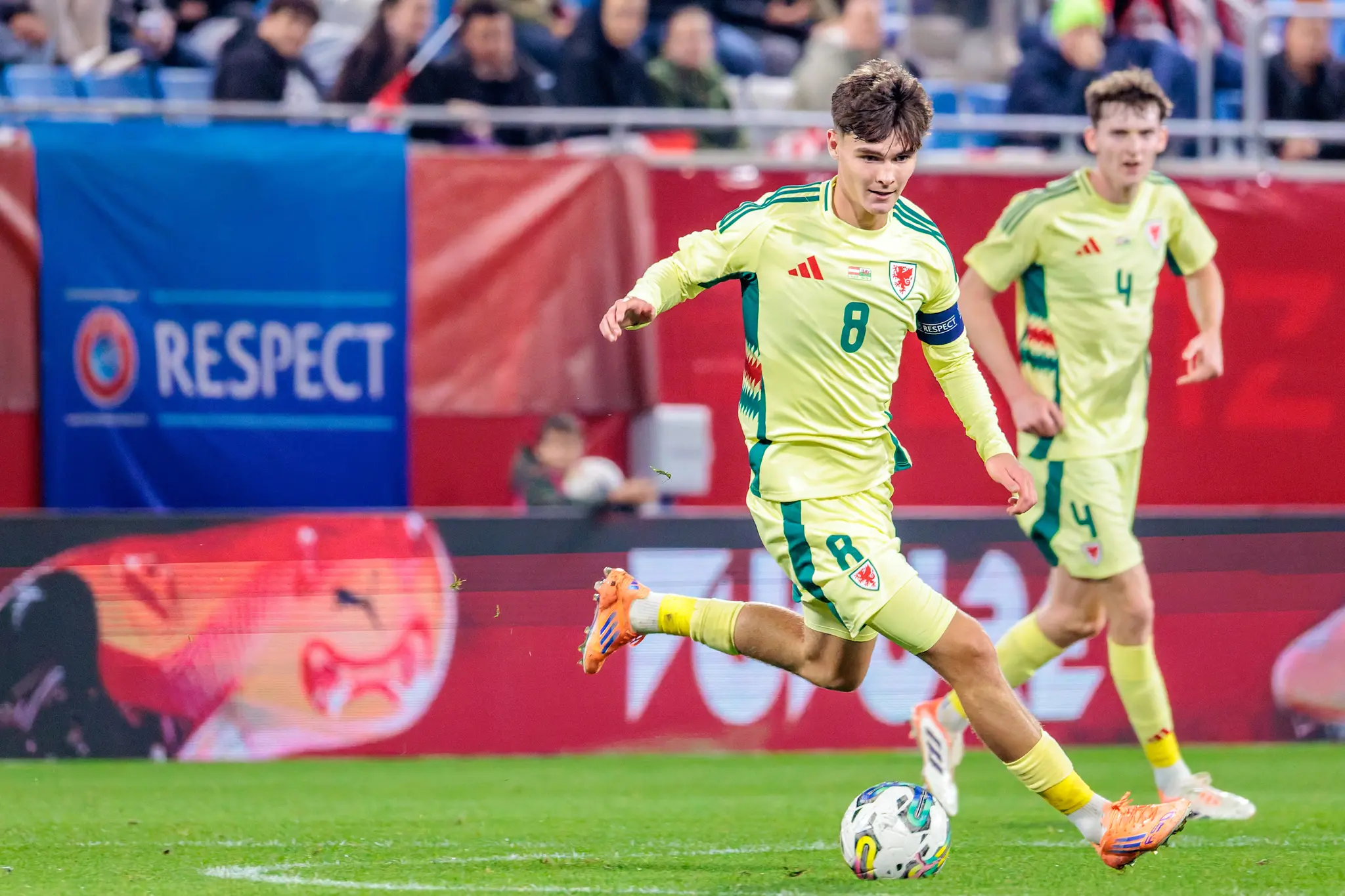 Der walisische U21-Kapitän Charlie Crew führt im hellgrünen Trikot mit der Nummer 8 den Ball während des EM-Qualifikationsspiels am Fuß
