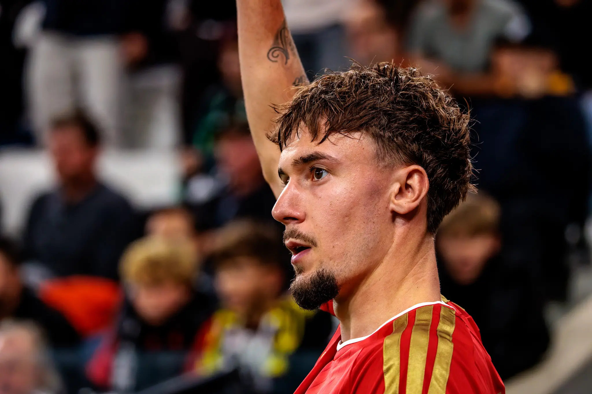 LASK-Einwechselspieler Christoph Lang (27) reckt den Arm nach oben und fordert eine Eingabe - sein Tattoo glänzt im Flutlicht.