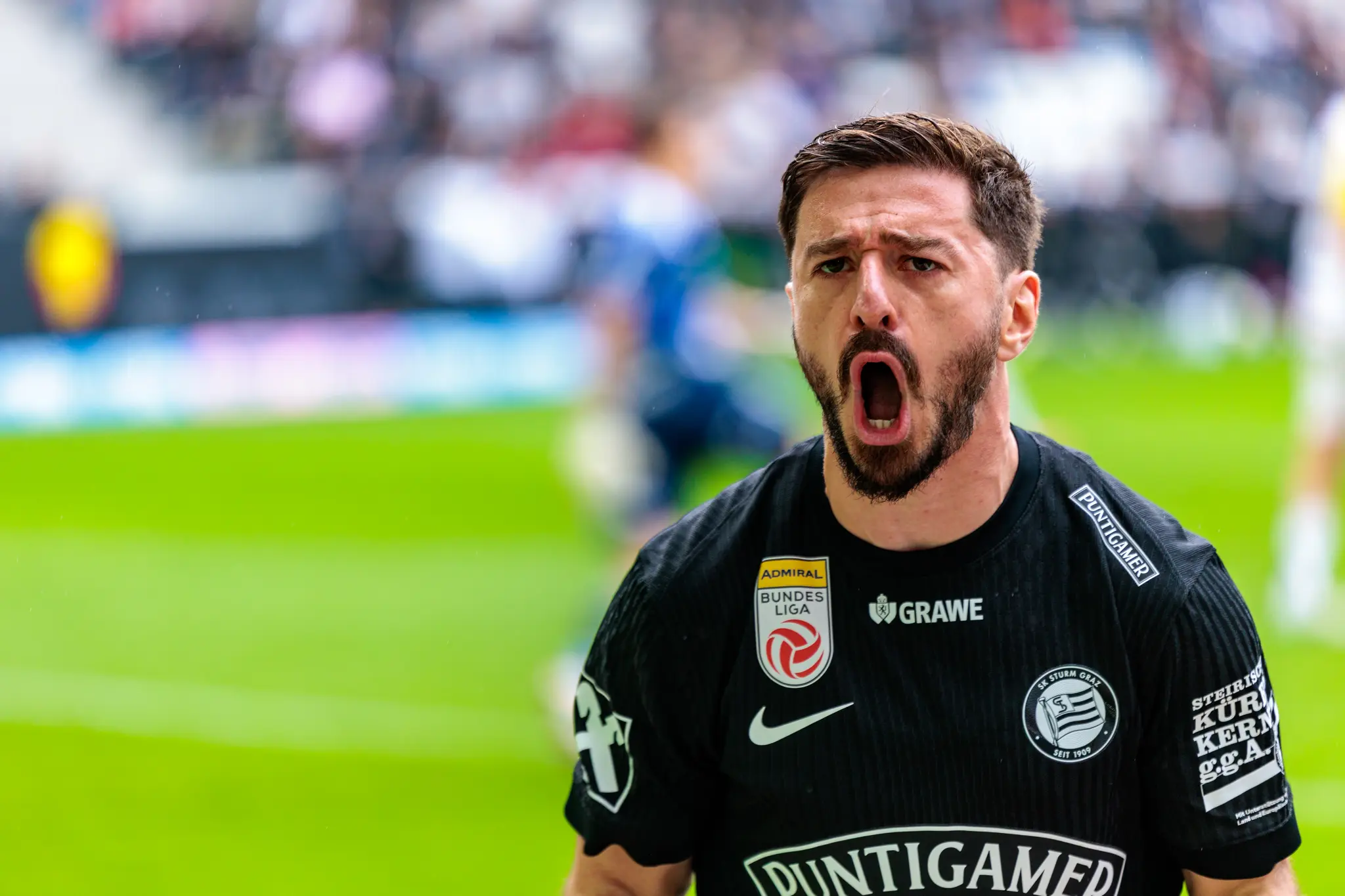Ein Sturm Graz Spieler jubelt mit weit geöffnetem Mund nach einem Tor