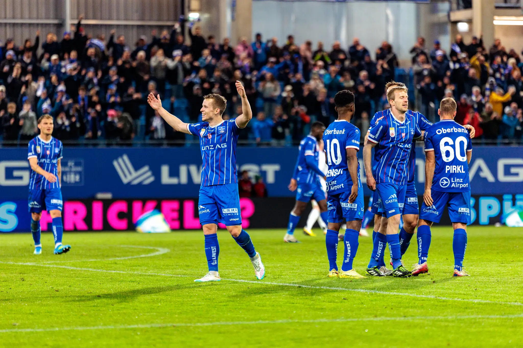 Ein Spieler des FC Blau-Weiß Linz feiert ausgelassen einen Torjubel vor jubelnden Zuschauern im Stadion